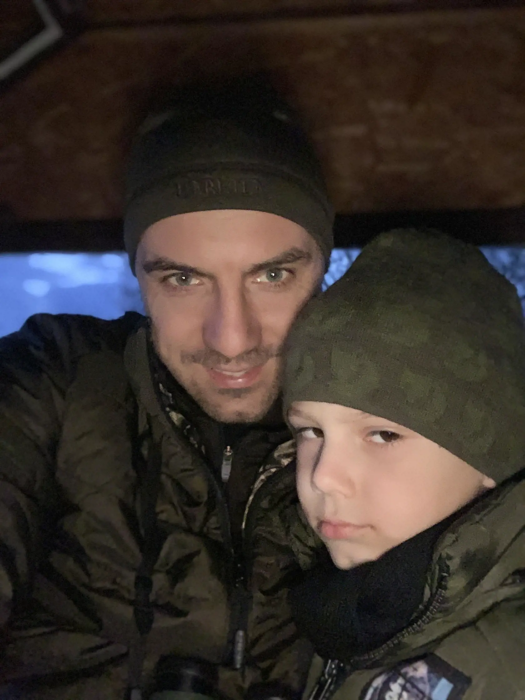 Dvojica poľovníkov na posede. Zente pôsobí unavene.
