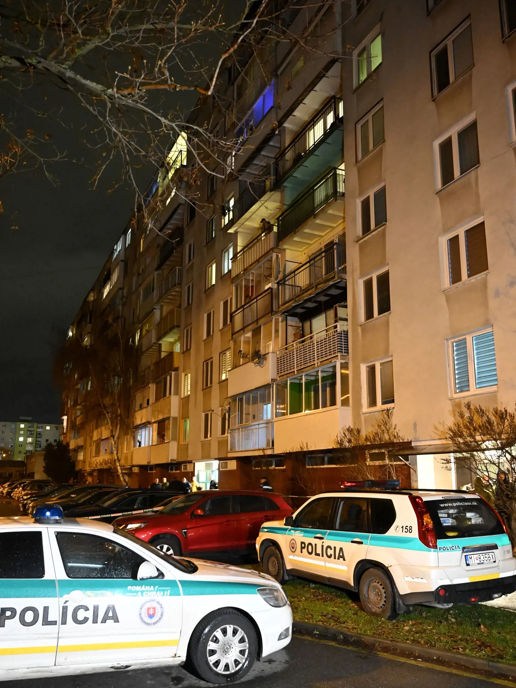 Na snímke policajné autá parkujú pred bytovým domom na Bieloruskej ulici v Michalovciach v utorok 17. januára 2023. V jednom z bytov na sídlisku v Michalovciach našli v utorok podvečer štyri osoby bez známok života. FOTO TASR - Roman Hanc