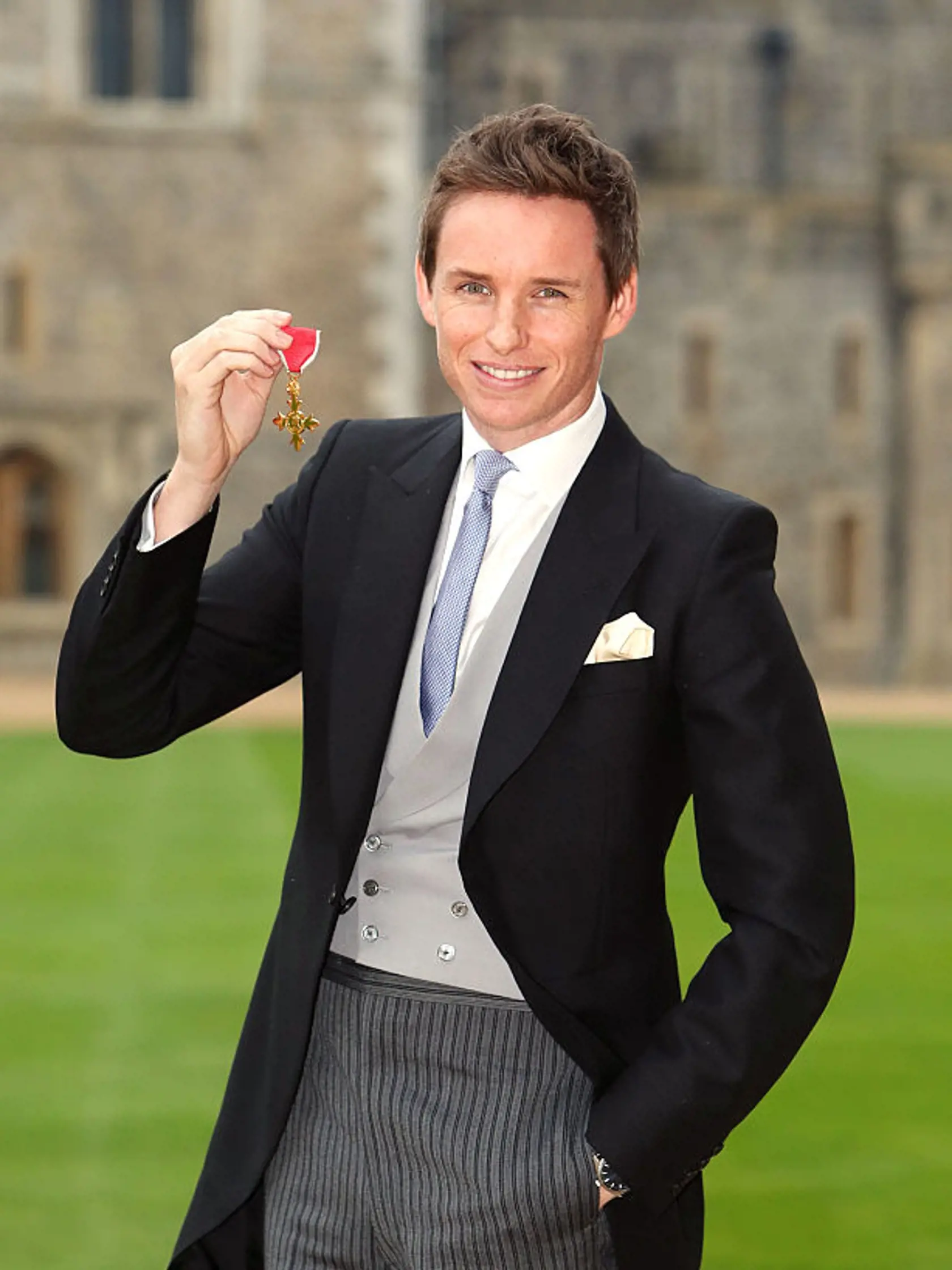 WINDSOR ,ENGLAND - DECEMBER 2: Eddie Redmayne poses after he was made an OBE (Officer of the Order of the British Empire) by Queen Elizabeth II during an investiture ceremony at Windsor Castle on  December 2, 2016 in Windsor, England.  (Photo by Steve Parsons-WPA Pool/Getty Images)