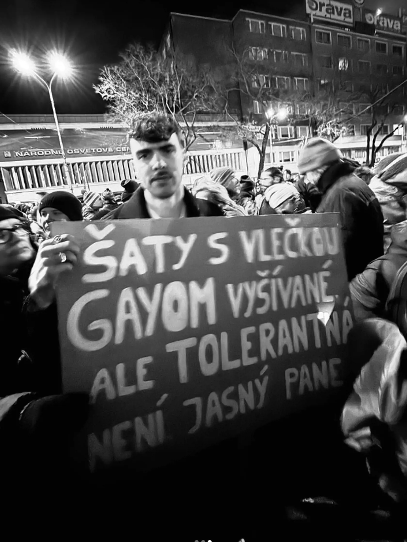 Spevák Adam Pavlovčin na proteste s transparentom proti Šimkovičovej.
