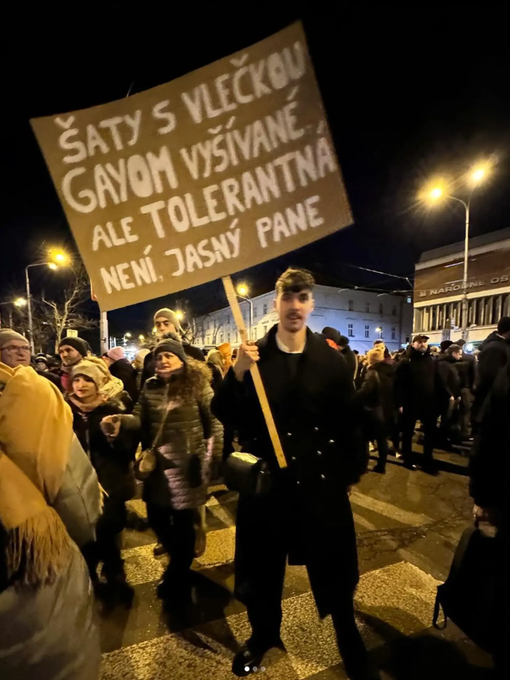 Spevák Adam Pavlovčin na proteste s transparentom proti Šimkovičovej.