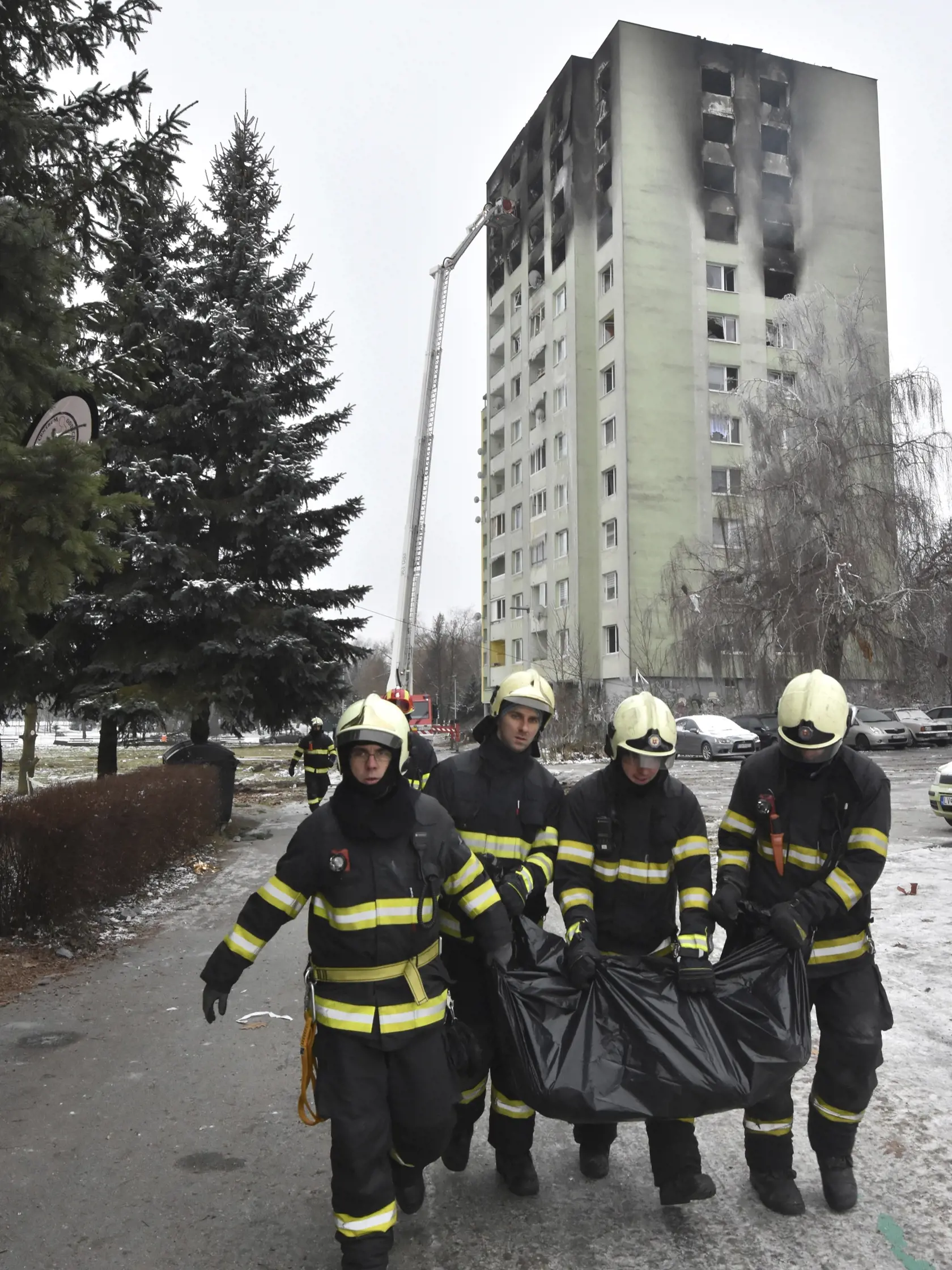Hasiči nesú z trosiek panelového domu na Mukačevskej ulici v Prešove telesné pozostatky jednej z obetí ničivého výbuch plynu v sobotu 7. decembra 2019. FOTO TASR - Vladimír Benko/MV SR
