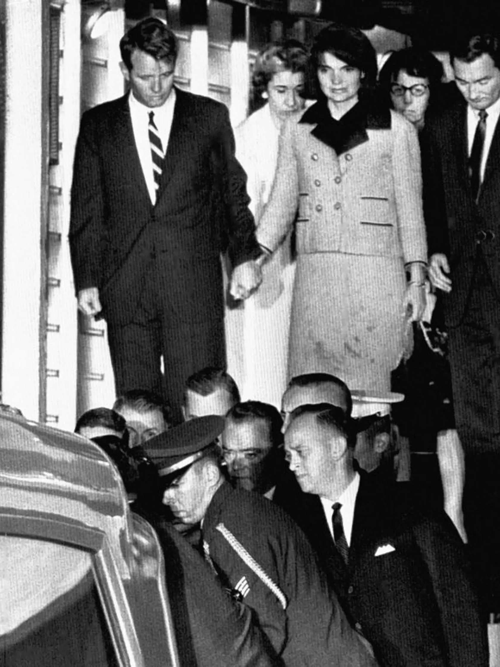 KK18 Andrewsova letecká základňa - Na archívnej snímke z 22. novembra 1963 Jacqueline Kennedyová v zakrvavenom kostýme drží za ruku svojho švagra Roberta Kennedyho, pred nimi nakladujú do sanitky truhlu s pozostatkami amerického prezidenta Johna F. Kennedyho na Andrewsovej leteckej základni neďaleko Washingtonu.  Dňa 22. novembra 2013 uplynie od atentátu na prezidenta Johna Fitzgeralda Kennedyho 50 rokov. Stalo sa to 22. novembra 1963 počas jeho cesty po Texase, ktorú absolvoval v súvislosti s b
