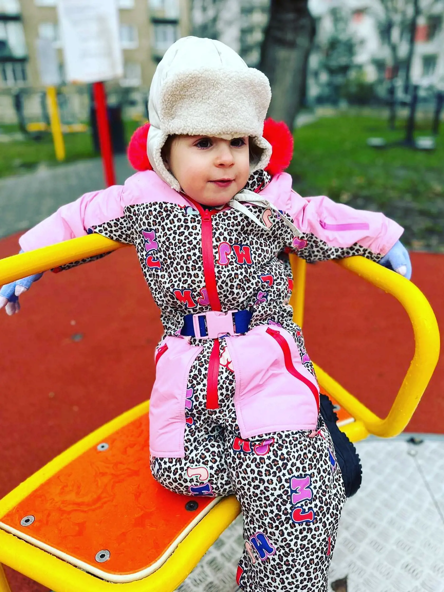 Ružová prešívaná zateplená kombinéza do snehu so zvieracou potlačou a s červenou kožušinkou na kapucni je z dielne známeho módneho domu Marc Jacobs a stojí v prepočte okolo 350 eur.