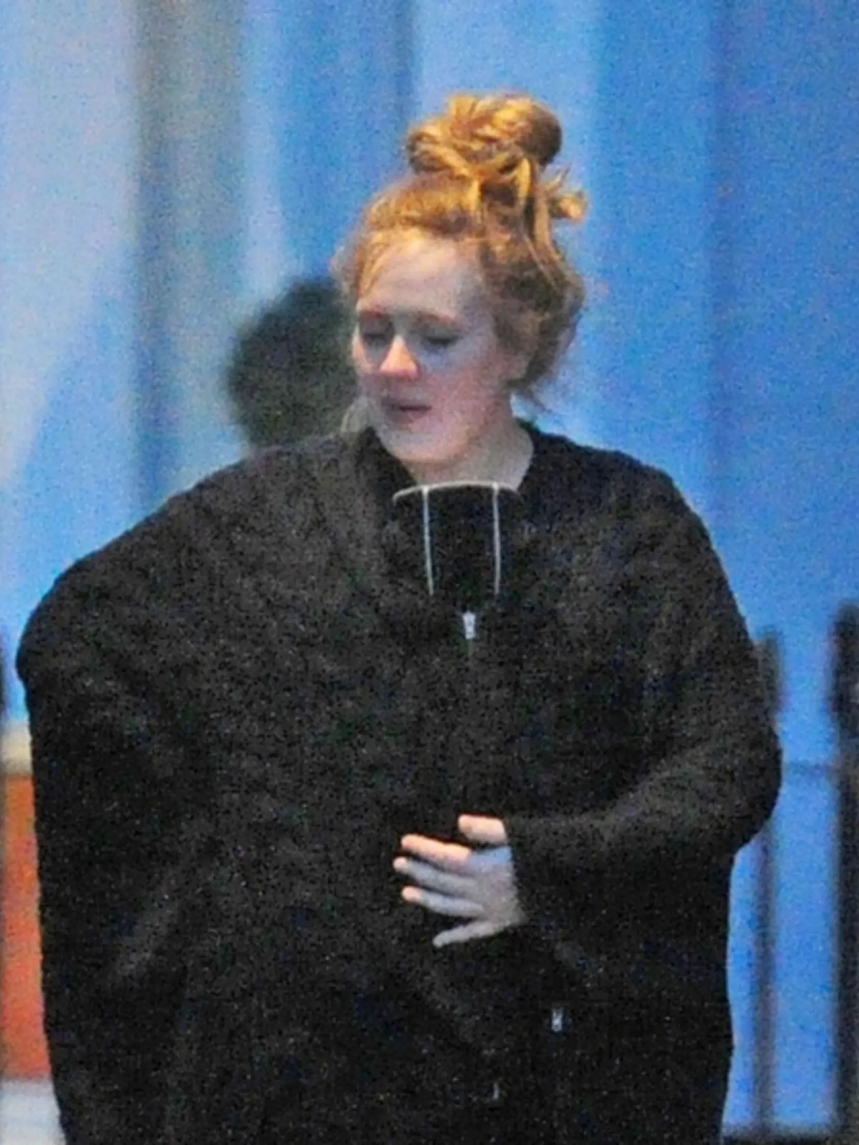 Adele na prechádzke so synom, ktorého má skrytého v náručí.