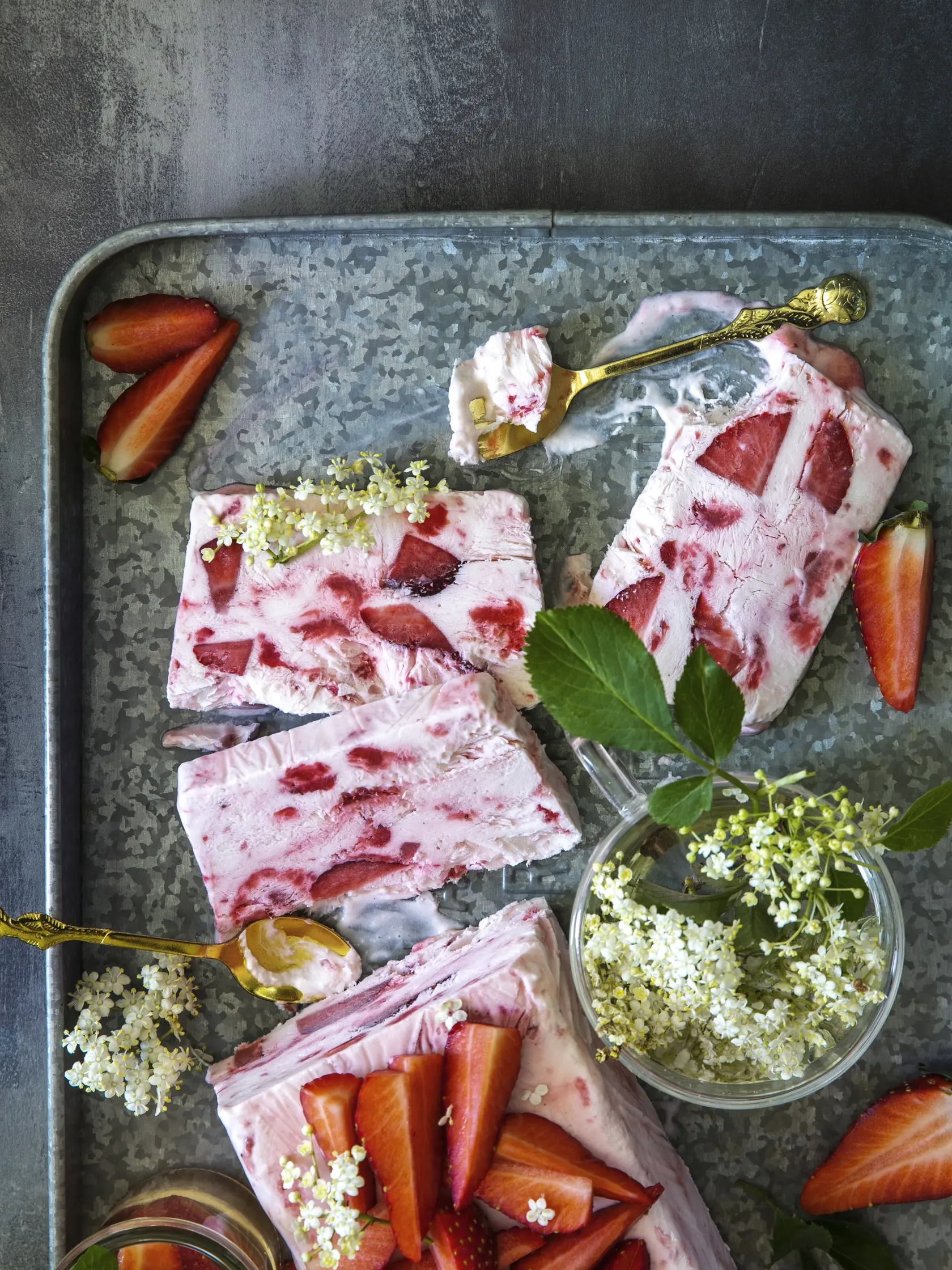 jahodovo bazové semifreddo

recept:
10 PORCIÍ PRÍPRAVA 25 MINÚT + MRAZENIE
• 500 g jahôd
• 50 g krupicového cukru
• 6 lyžíc bazového sirupu
• 300 g šľahačkovej smotany
• 300 g hustého gréckeho jogurtu
1. Litrovú formu na chlieb vysteľte potravi- nárskou fóliou. Do hrnca vsypte 300 g očis- tených jahôd nakrájaných na menšie kúsky. Pridajte cukor, 4 lyžice bazového sirupu. Varte, kým jahody nepustia šťavu a tá sa na polovicu zredukuje. Nechajte vychladnúť.
2. Smotan