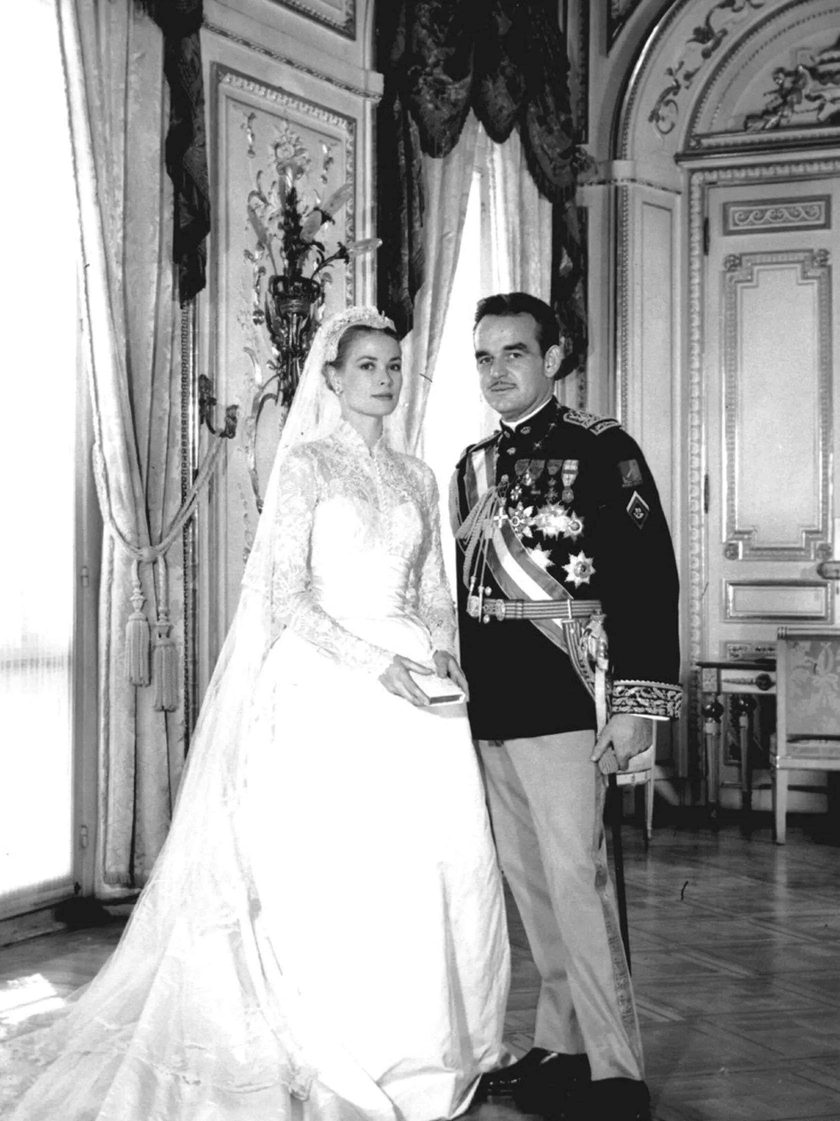 Grace Kelly († 52) monacká kňažná a bývalá filmová hviezda si 19. apríla 1956 vzala za manžela monacké knieža Rainiera III. Na túto príležitosť zvolila ikonické šaty, ktoré jej stvorila Helen Rose. Táto dizajnérka sa jej starala aj o väčšinu rób v čase jej filmovej kariéry. Taftové šaty s opaskom boli doplnené špeciálnou tiarou a 125 rokov starým bruselským závojom. Nevesta mala aj nezvyčajný doplnok, vyšívanú modlitebnú knižku.