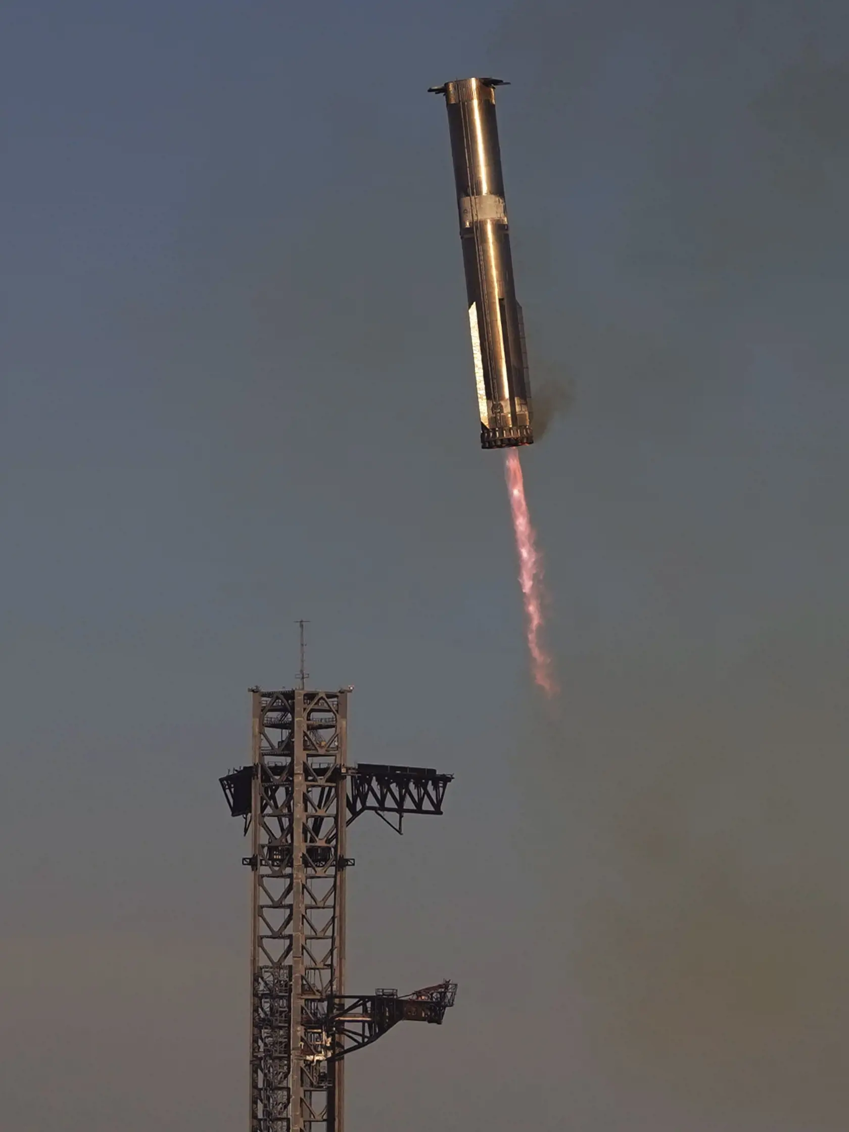 KK27 Boca Chica - V poradí siedmy skúšobný štart kozmickej lode Starship s nosnou raketou Super Heavy, určenou na pilotované lety na Mesiac, sa skončil neúspechom.  Štart sa uskutočnil zo štartovacej rampy vesmírnej základne SpaceX v Boca Chica v juhovýchodnom Texase vo štvrtok 16. januára 2025 o 17.00 h miestneho času. FOTO TASR/AP
SpaceX's mega rocket Starship booster returns to the launch pad during a test flight from Starbase in Boca Chica, Texas, Thursday, Jan. 16, 2025. (AP Photo/Eric Gay)