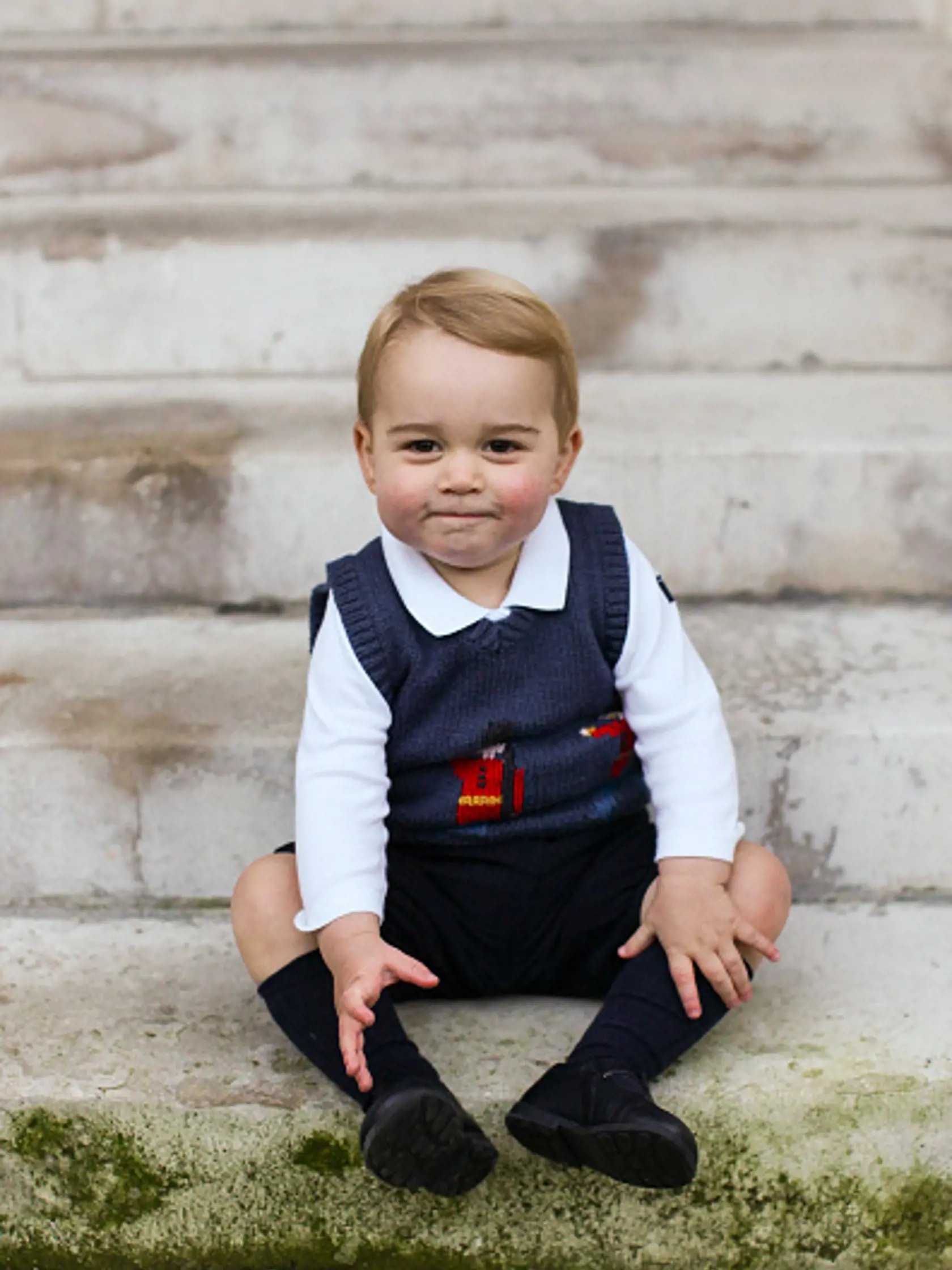 LONDON, ENGLAND - DECEMBER 13:  (Getty Images provides access to this publicly distributed image for editorial use only and is not the copyright owner. No Sales - No Commercial Use) In this handout image of three released on December 13, 2014 by Kensington Palace, Prince George sits for his official Christmas picture in a courtyard at Kensington Palace in late November of 2014 in London, England.  (Photo by The Duke and Duchess of Cambridge/PA Wire via Getty Images)