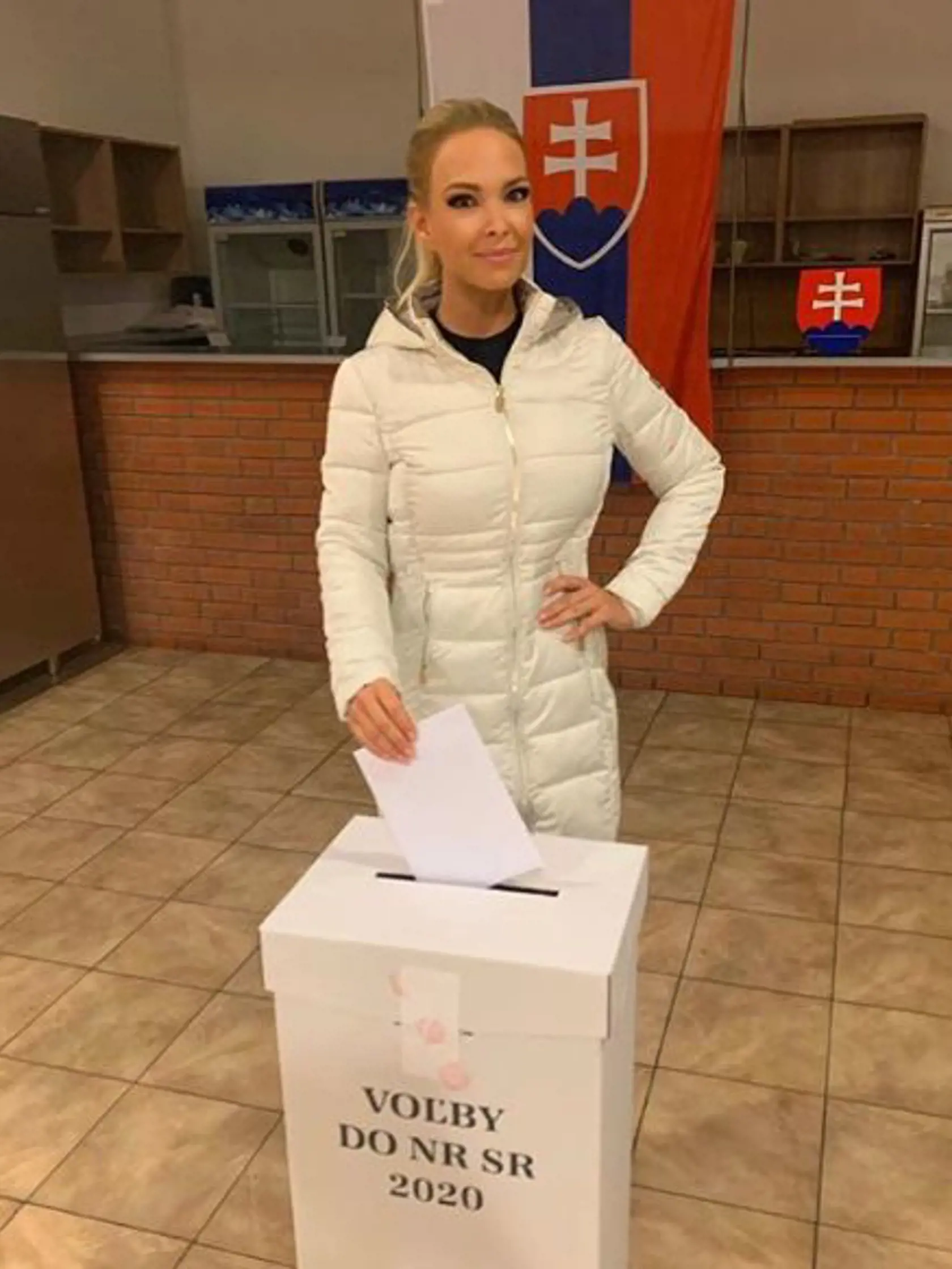 Jojkárka Lucia Barmošová pri hádzaní lístku do urny počas volieb 2020.