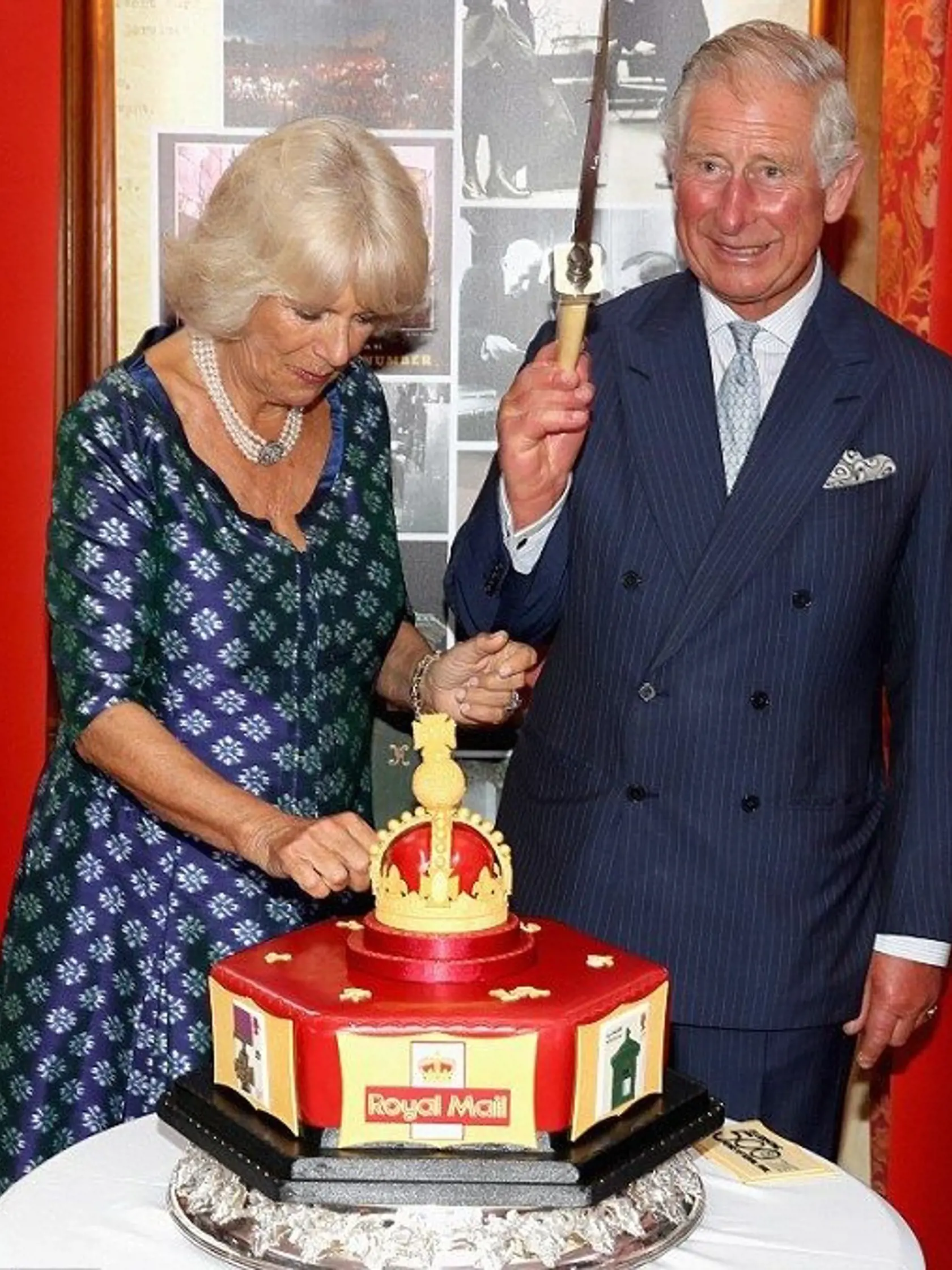 Camilla a Charles krájajú tortu pri príležitosti 500.výročia kráľovskej pošty.
