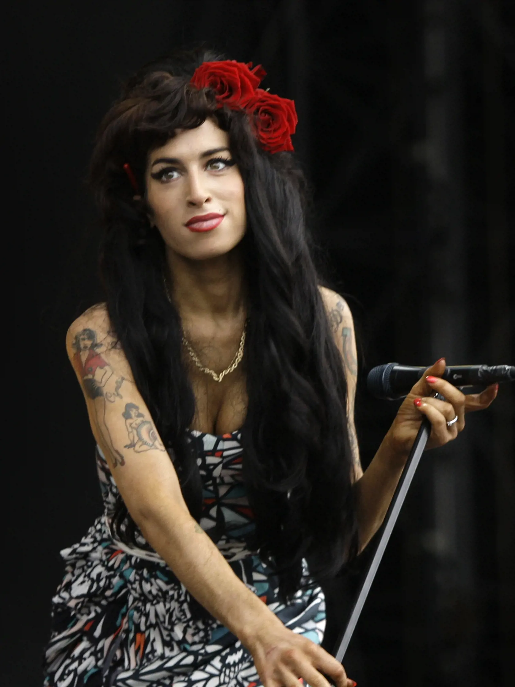 FILE - In this Aug. 17, 2008 file photo, Amy Winehouse performs at the V Festival in Essex, England, after which, according to her father, Mitch Winehouse, she will play one more gig before taking an extended break from playing live after Sept. 6. The documentary film, “Amy,” looks at the talent and career of Winehouse, and how fame and her battle with bulimia, depression and addiction contributed to her death at age 27. The film is in theaters now. (AP Photo/Joel Ryan, File)