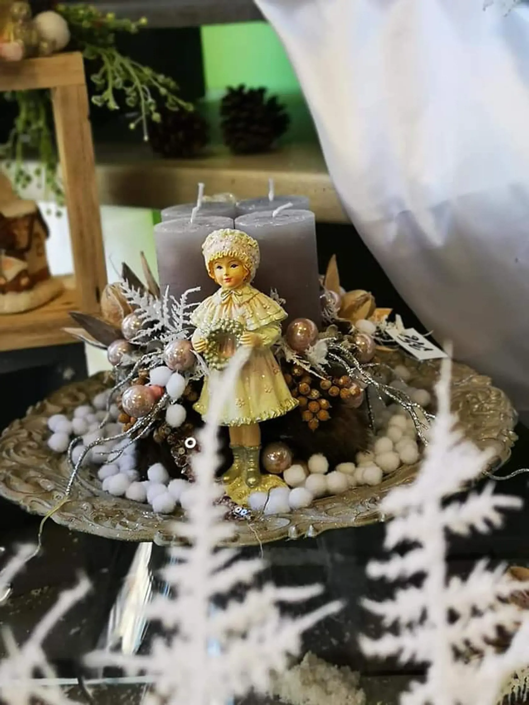 Dekorácia s figúrkou dievčatka a sviečkami.