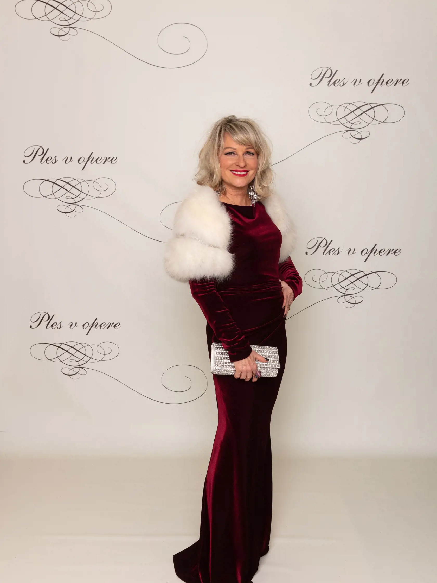 Simona Bubánová: Manželka Janka Kurica, Simona Bubánová, si na ples vybrala bordové úzke šaty zo zamatovej látky. Ramená jej zdobilo biele kožušinové bolerko.