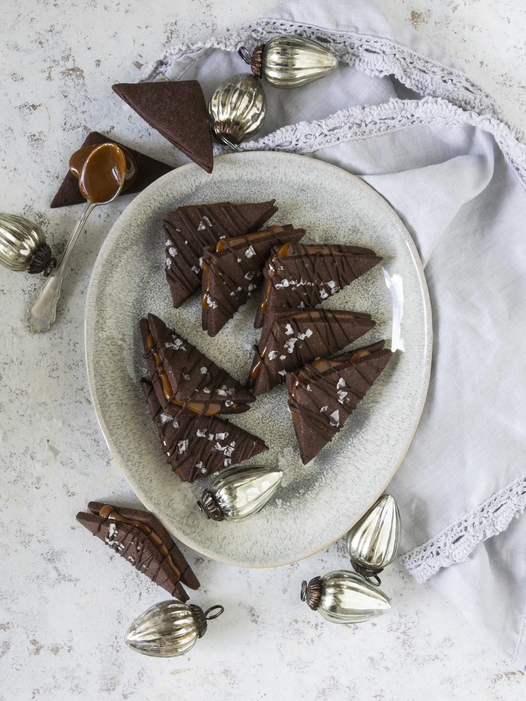 kakaové pečivo s karamelom

recept:
20 AŽ 25 KUSOV, PRÍPRAVA 30 MINÚT + CHLADENIE, PEČENIE 10 MINÚT
Na cesto:
• 280 g hladkej múky • 30 g kakaa holandského typu • 120 g práškového cukru • štvrť lyžičky kypriaceho prášku • štipka soli • 200 g masla • 1 vajce
Na karamel:
• 200 g cukru • 2 lyžice vody • 150 ml šľahačkovej smotany • soľ
Na ozdobenie:
• 50 g tmavej čokolády • vločková soľ
1. Na cesto zmiešajte múku, kakao, cukor, kypriaci prášok a štipku soli. Pridajte