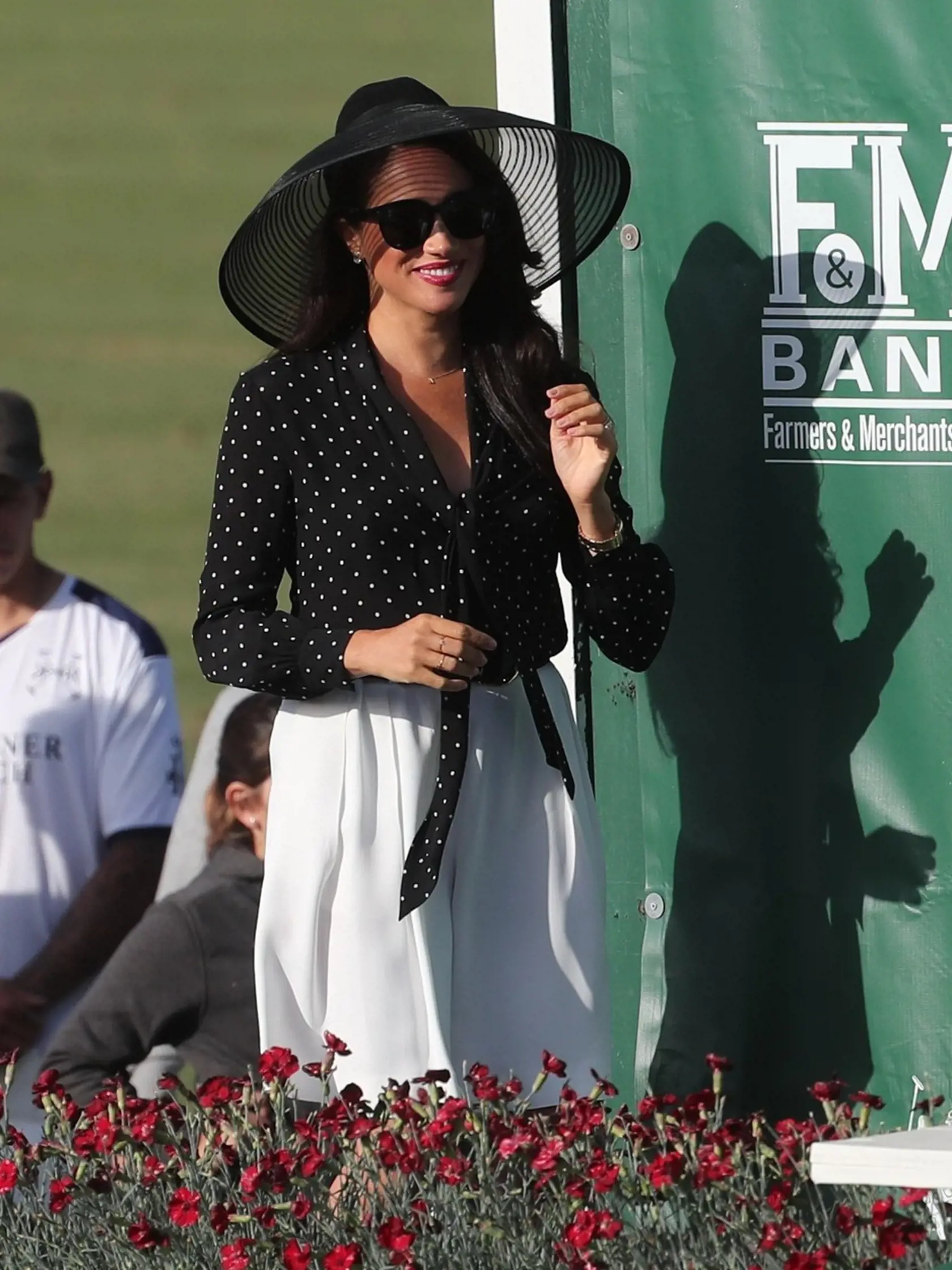 Meghan Markle prišla podporiť princa Harryho. Oblečené mala voľné biele nohavice, čiernu blúzku a čierny klobúk.