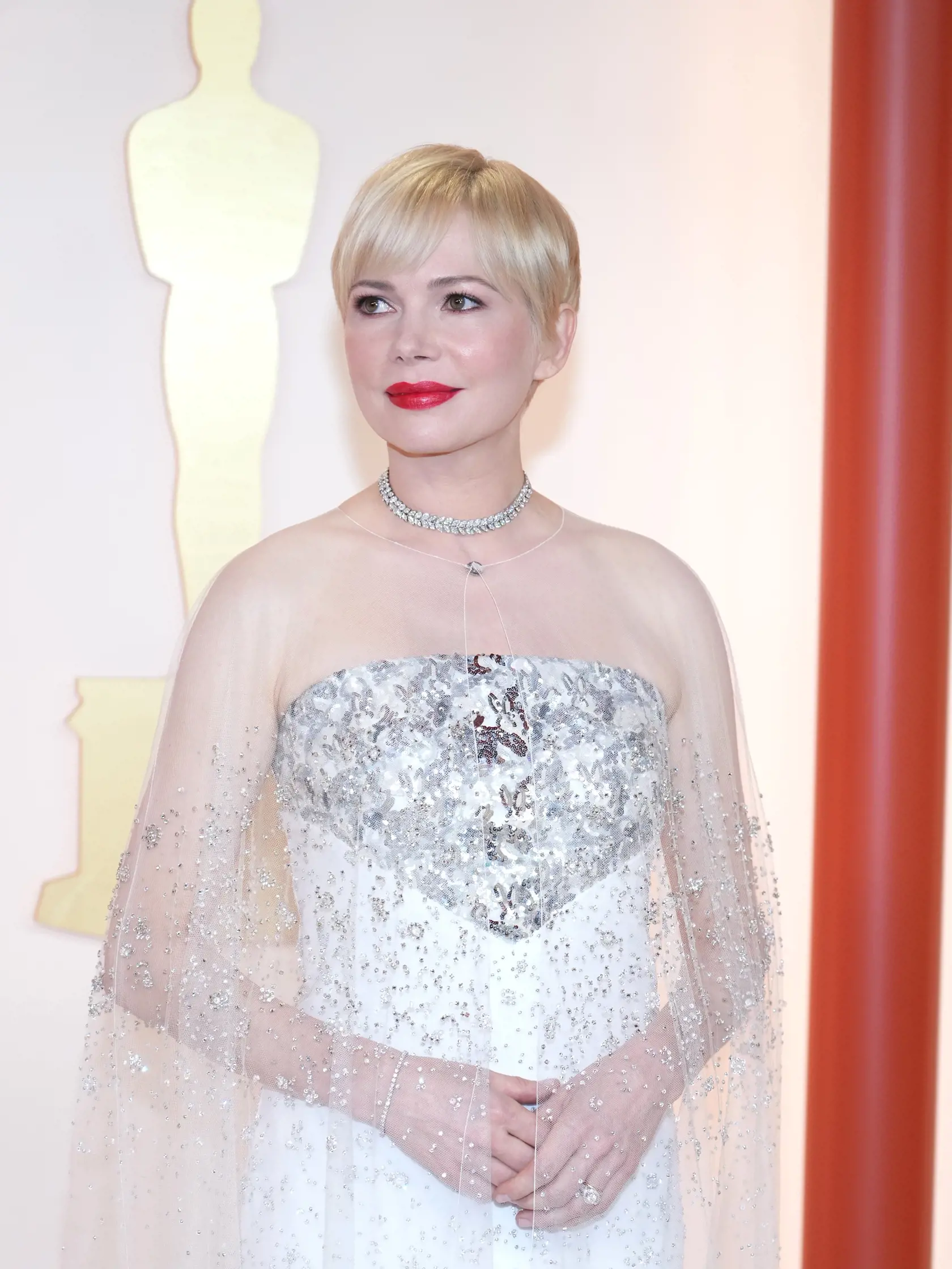 Michelle Williams (42) spáchala zločin proti móde vo svojich bielych šatách bez ramienok, na ktorých visel trblietavý, priesvitný kus látky.