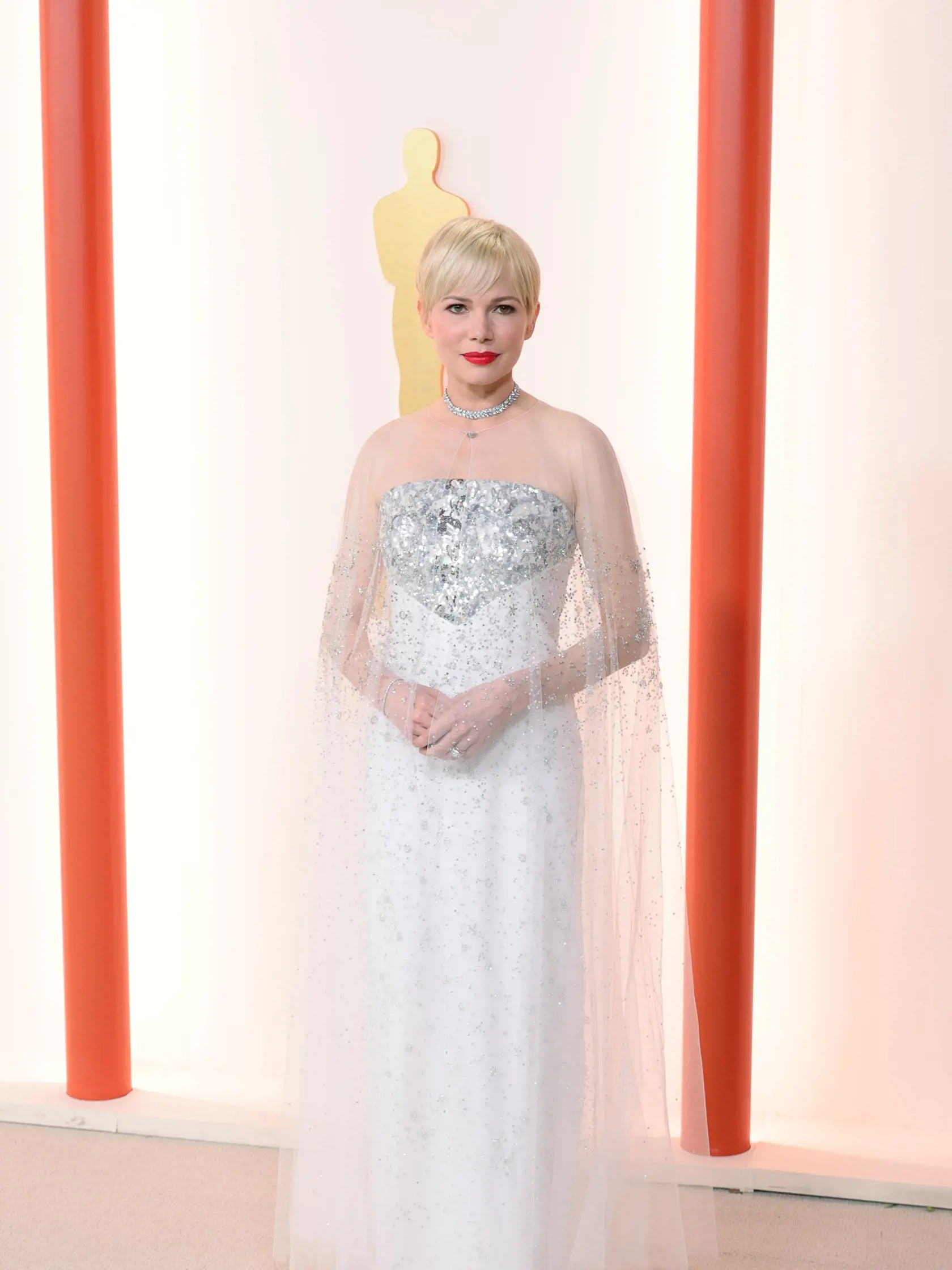 Michelle Williams (42) spáchala zločin proti móde vo svojich bielych šatách bez ramienok, na ktorých visel trblietavý, priesvitný kus látky.