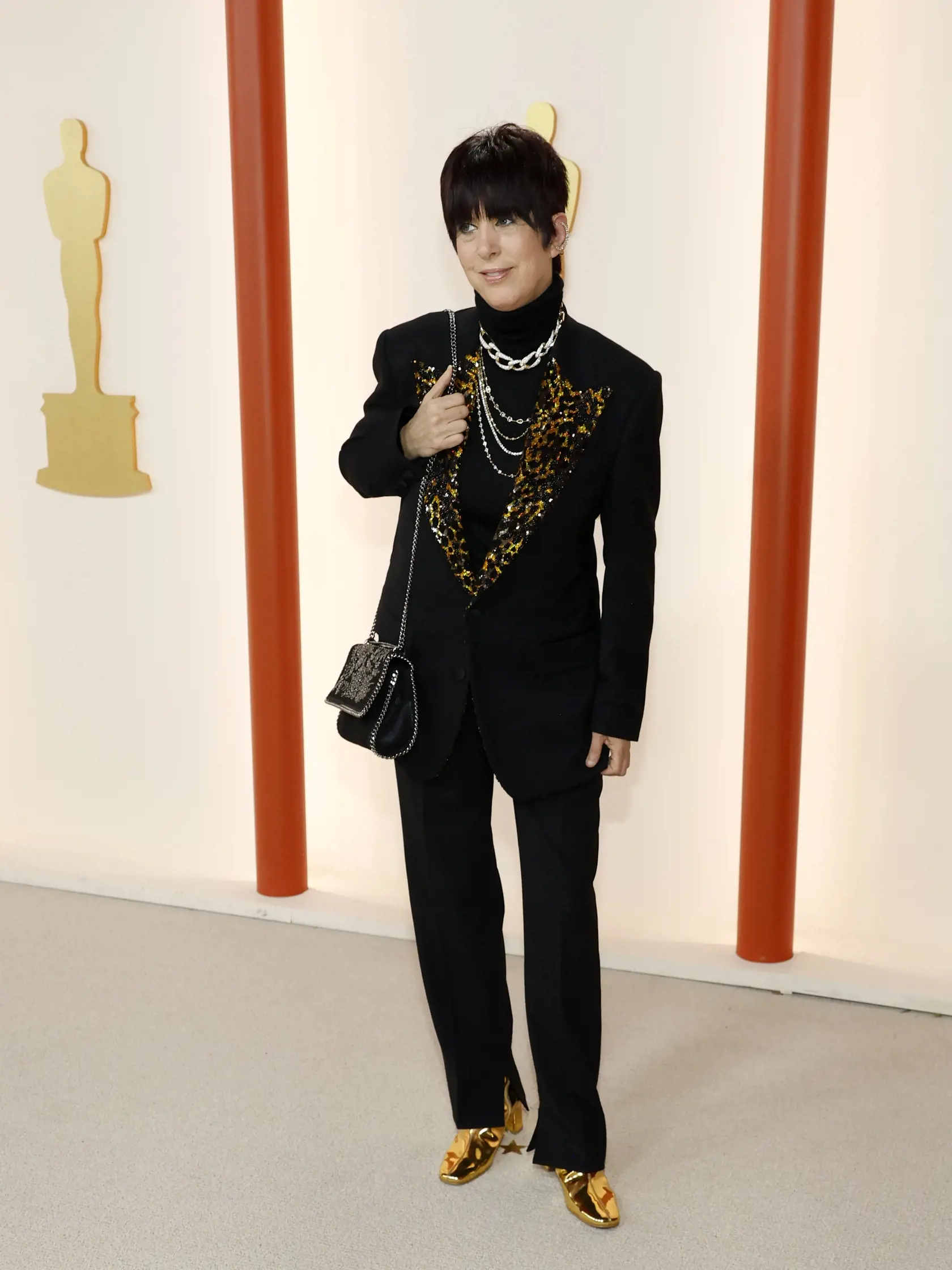 Skladateľka Diane Warren prišla v bizarnom vzhľade, ktorý obsahoval čierny oblek s leopardím vzorom a metalické zlaté topánky.