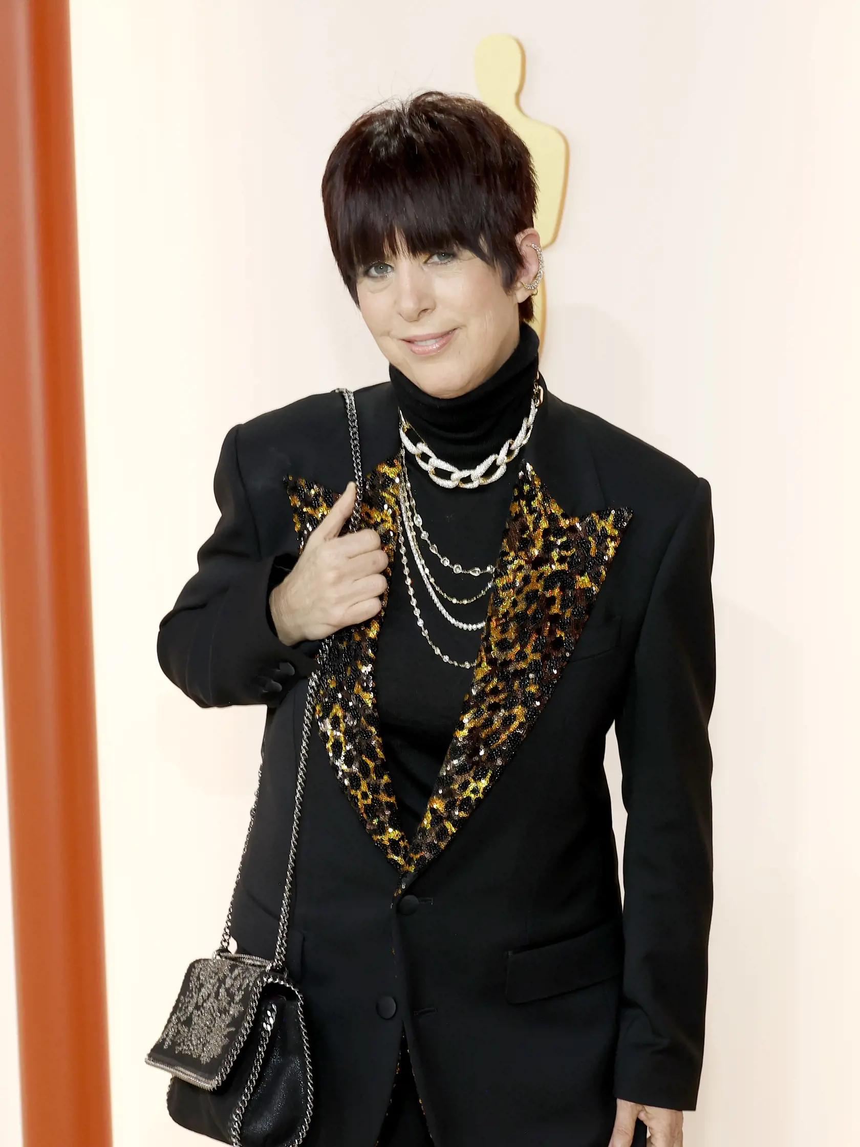 Skladateľka Diane Warren prišla v bizarnom vzhľade, ktorý obsahoval čierny oblek s leopardím vzorom a metalické zlaté topánky.
