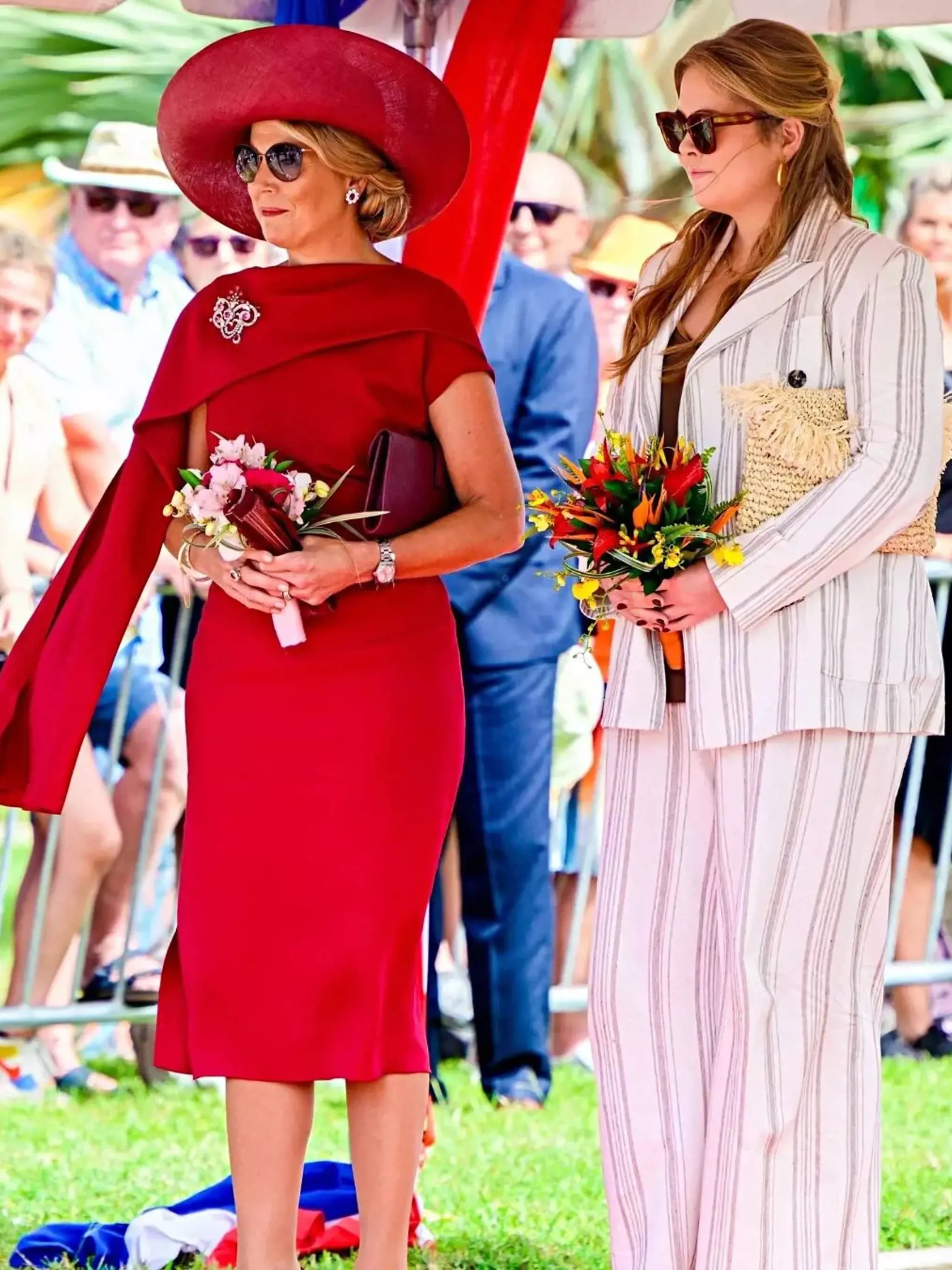 Kráľovná Máxima v elegantných červených puzdrových šatách a rozmerným klobúkom. Na snímke s dcérou - holandskou princeznou Amaliou.