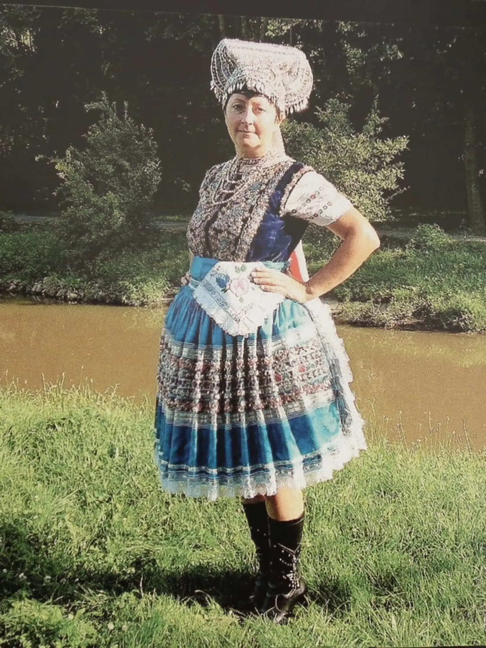 Marta Benčová má na sebe najslávnostnejší kroj, aký mohla mať oblečený mladá vydatá žena. Jeho súčasťou bola nielen vesta „bruslik“ plná výšiviek a „blingáčov“, ale aj brokátová sukňa, na ktorej boli tiež „blingáče“ a nosila sa len výnimočne. Tým, že bola podšitá papierom sa nesmela prať. Čistila sa špeciálne, a aj preto vydržala dlhé desaťročia. Veľmi pekne zdobené boli aj kožené čižmy.