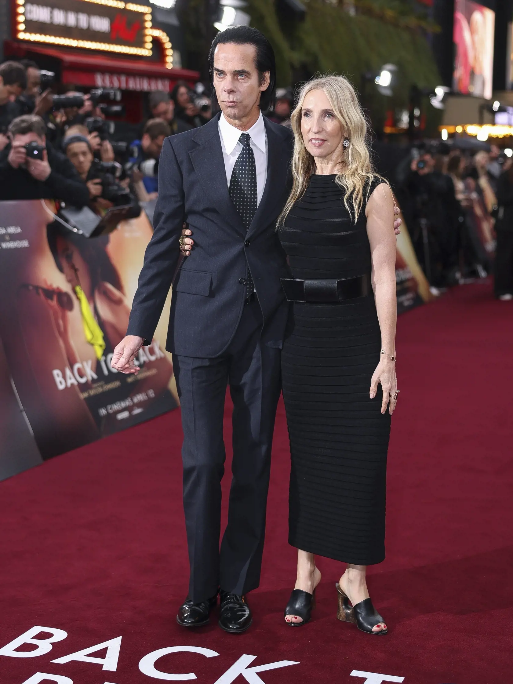 Na snímke sprava britská režisérka Sam Taylor-Johnson aaustrálsky spevák Nick Cave prichádzajú na premiéru životopisného dramatického filmu Back to Black založeného na živote britskej speváčky a skladateľky Amy Winehouse v Londýne 8. apríla 2024. FOTO TASR/AP