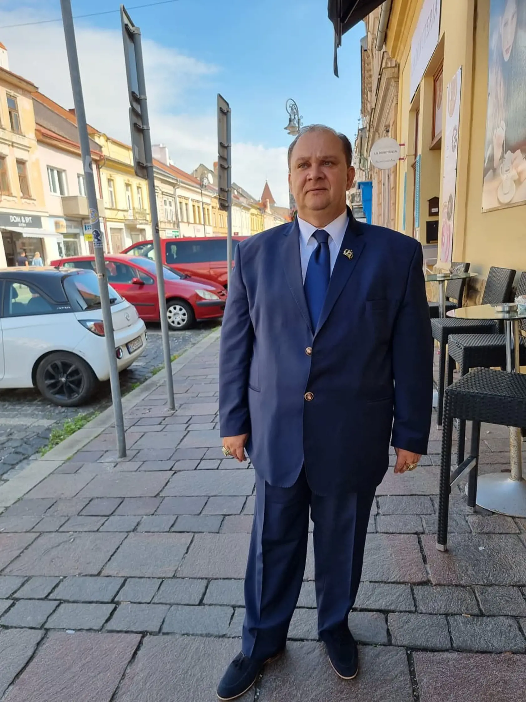 Botoš pozdravil pápeža Františka v tmavomodrom obleku s unikátnymi gombíkmi, bielej košeli a kravate vo farbe obleku.