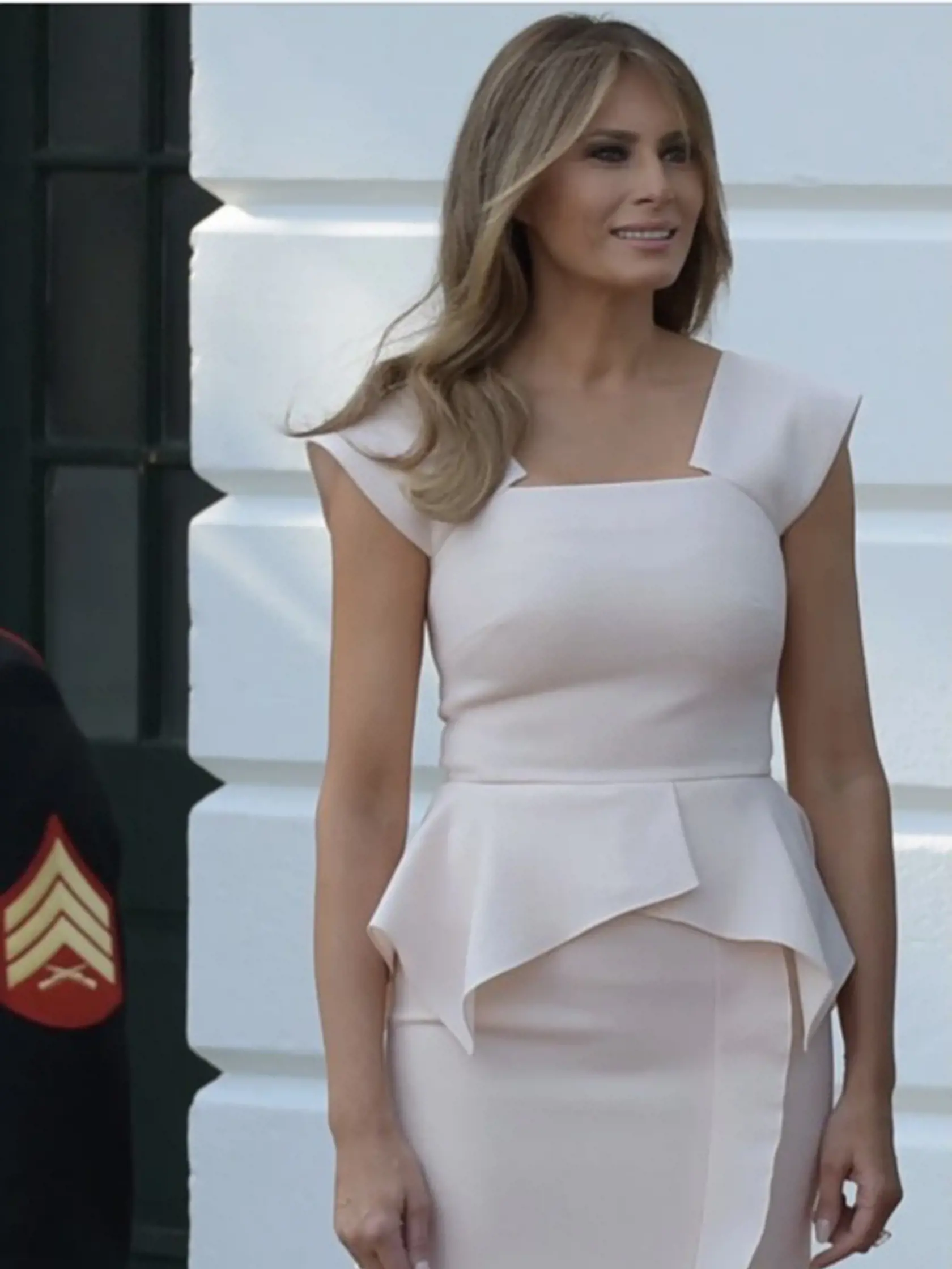 Melania v šatách s ozdobou v páse - peplum.