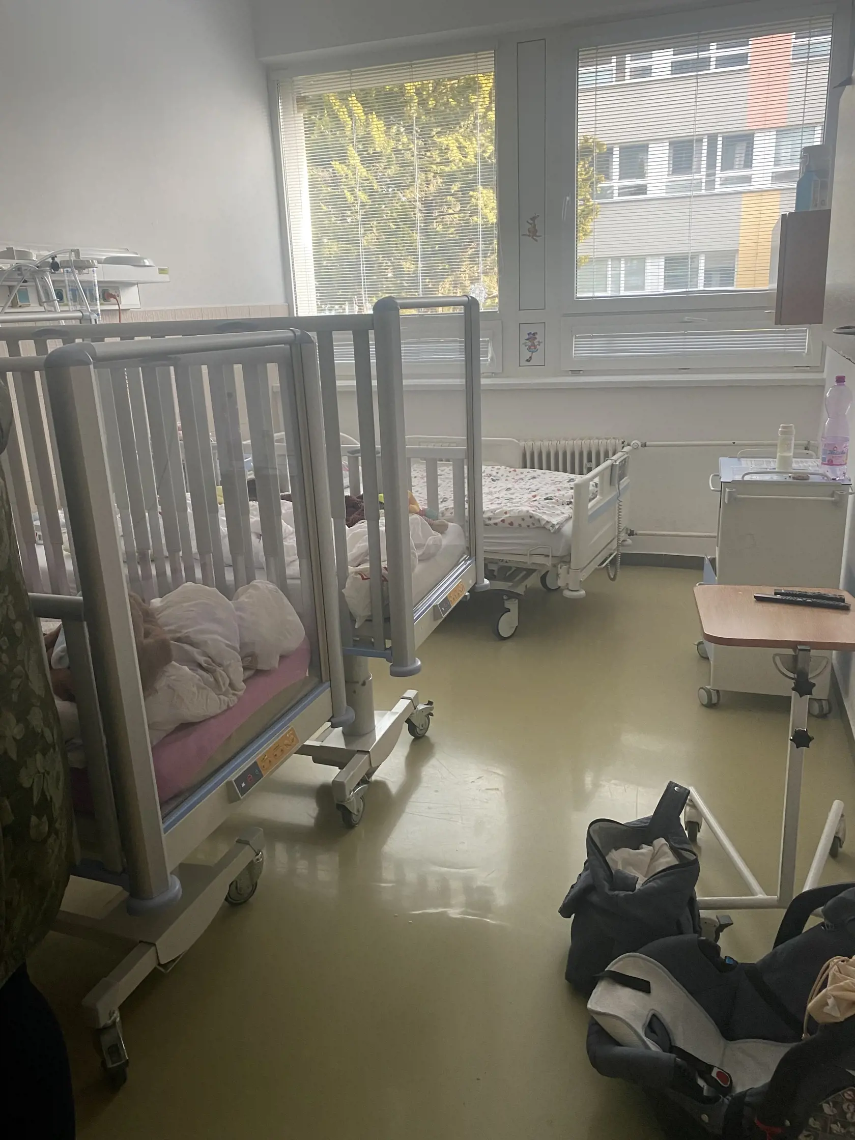 Posteľ vedľa postele a k tomu nevybalené tašky sprievodcov malých pacientov.