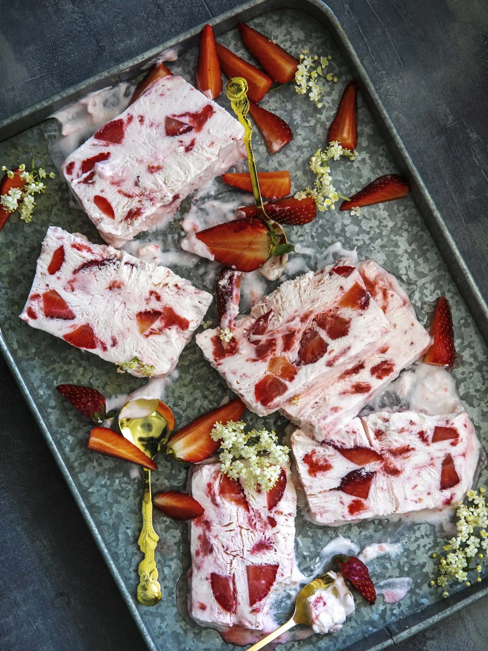 jahodovo bazové semifreddo

recept:
10 PORCIÍ PRÍPRAVA 25 MINÚT + MRAZENIE
• 500 g jahôd
• 50 g krupicového cukru
• 6 lyžíc bazového sirupu
• 300 g šľahačkovej smotany
• 300 g hustého gréckeho jogurtu
1. Litrovú formu na chlieb vysteľte potravi- nárskou fóliou. Do hrnca vsypte 300 g očis- tených jahôd nakrájaných na menšie kúsky. Pridajte cukor, 4 lyžice bazového sirupu. Varte, kým jahody nepustia šťavu a tá sa na polovicu zredukuje. Nechajte vychladnúť.
2. Smotan
