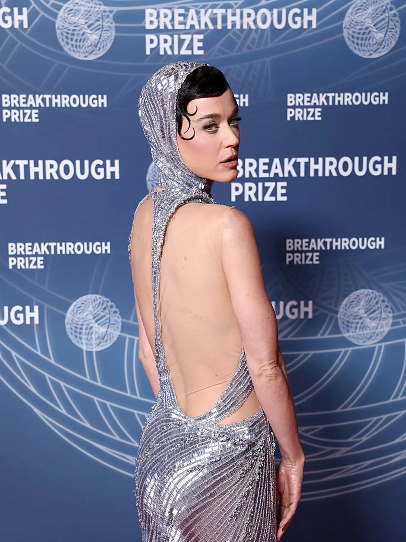 Speváčka Katy Perry zvolila futuristické strieborné šaty s výstrihom, ktorý odhaľoval jej dekolt aj chrbát. 