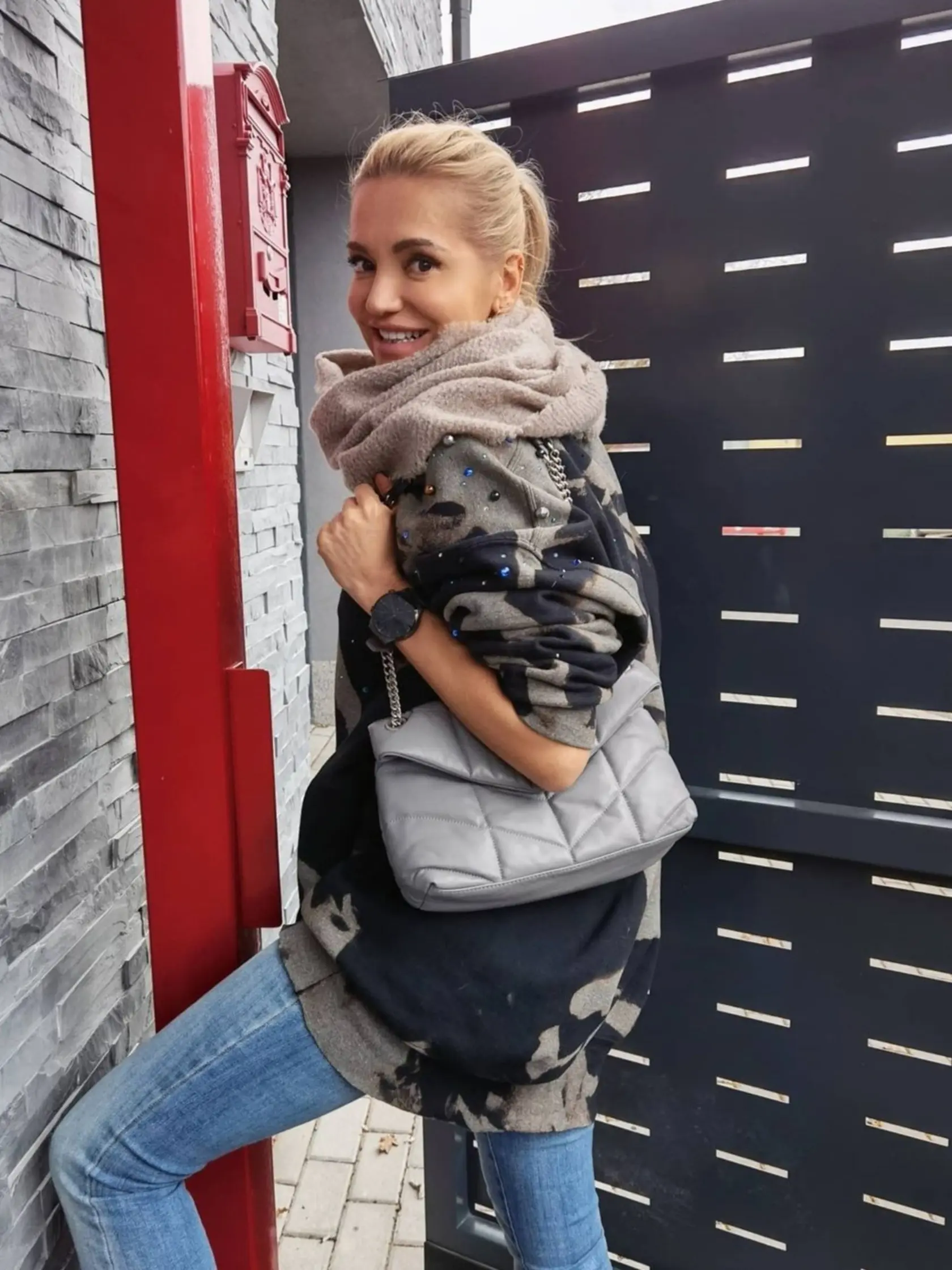 V tomto outfite by sme Dare rátali aj o 20 rokov menej. XL mikina s batikovým vzorom a našitými perličkami, sivá prešívaná kabelka, modré džínsy a kruhový šál. Rafinovaná ležérnosť v prírodných tónoch, VAU!