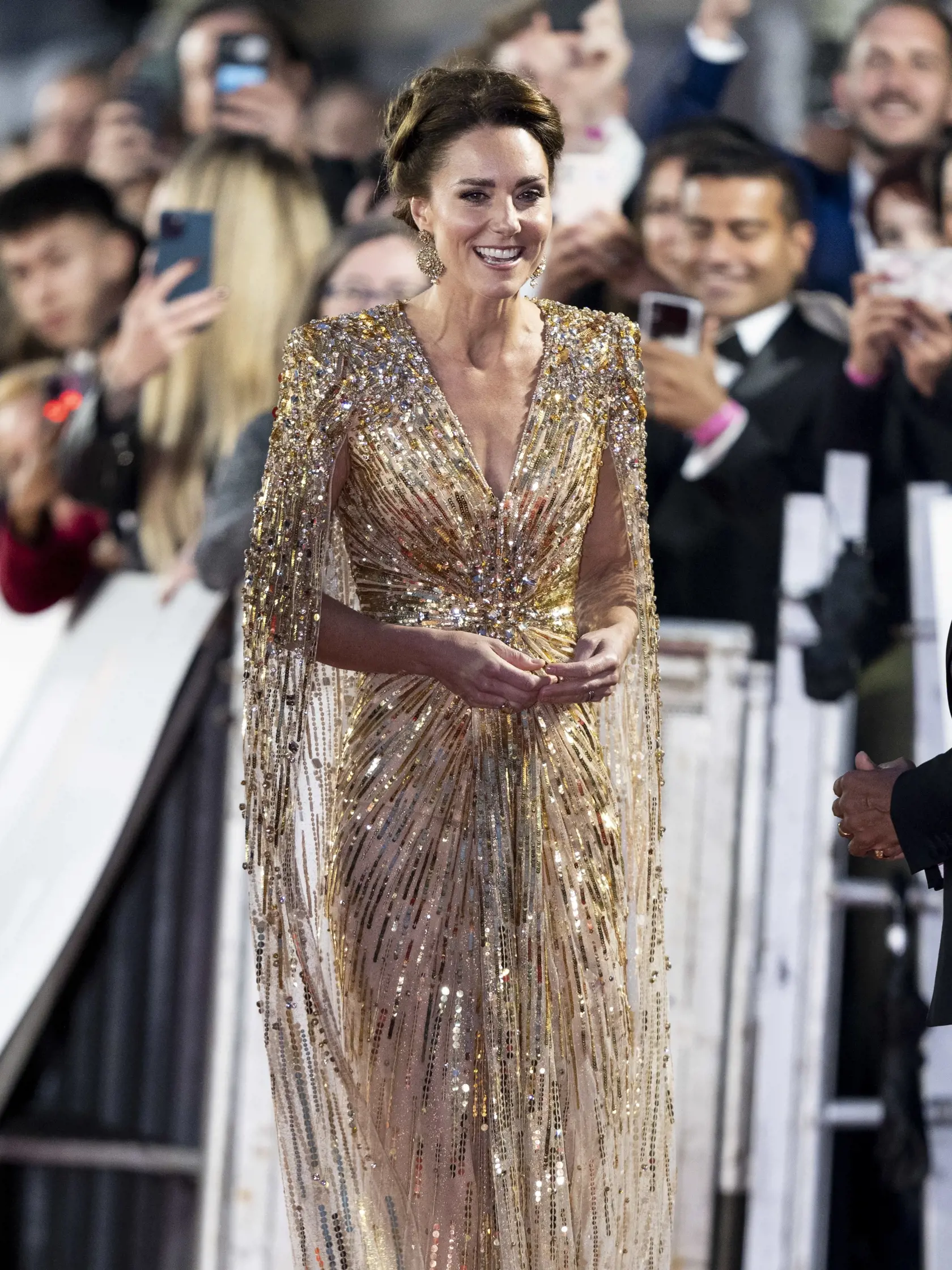 Vojvodkyňa Kate prišla v zlatých šatách od módnej návrhárky Jenny Packham v hodnote 3 200 eur a na sebe mala aj náušnice špeciálne vyrobené na mieru v hodnote 335 eur.
