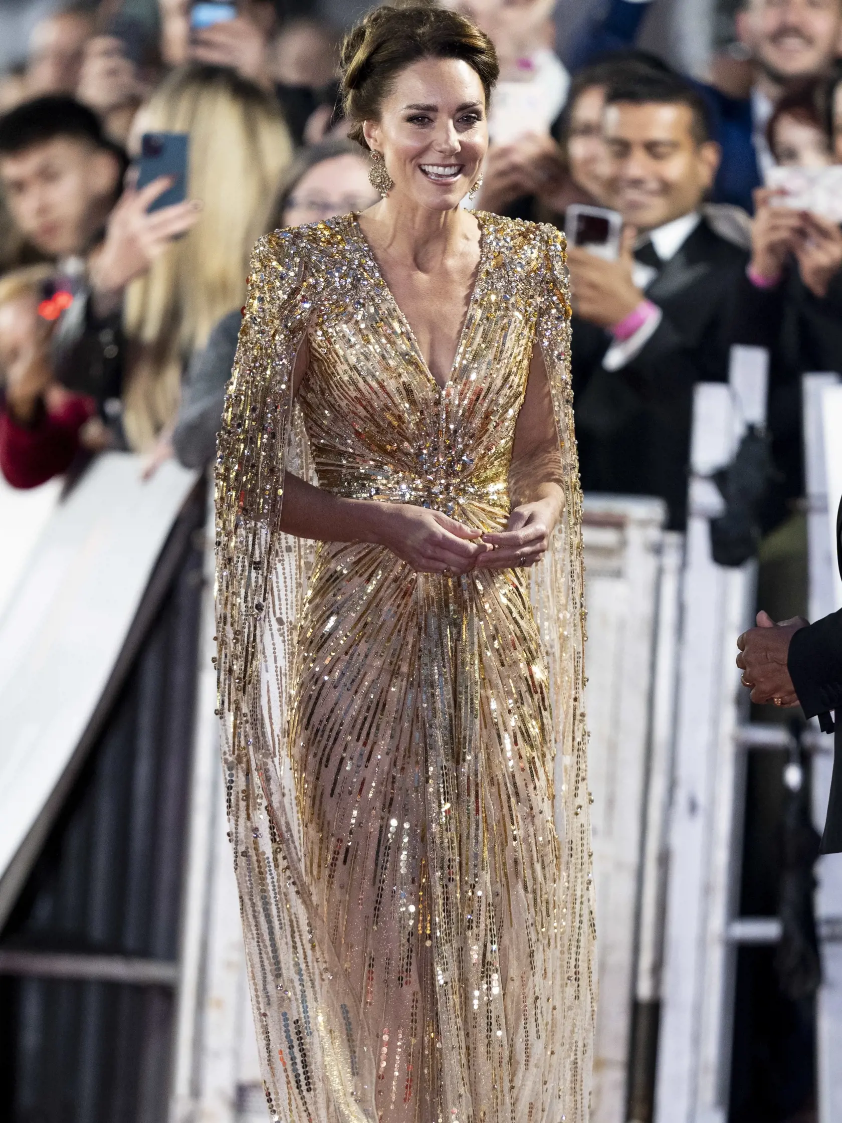 Vojvodkyňa Kate prišla v zlatých šatách od módnej návrhárky Jenny Packham v hodnote 3 200 eur a na sebe mala aj náušnice špeciálne vyrobené na mieru v hodnote 335 eur.