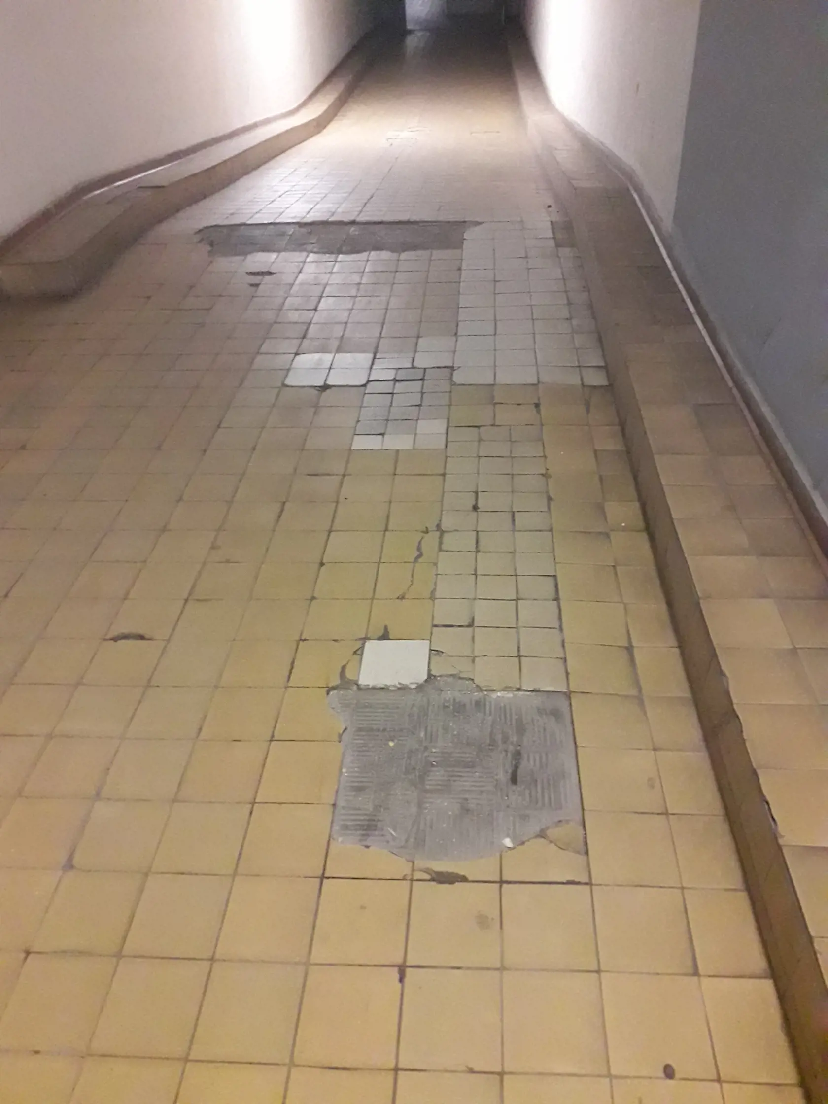 Dlažba je značne poškodená na viacerých miestach.