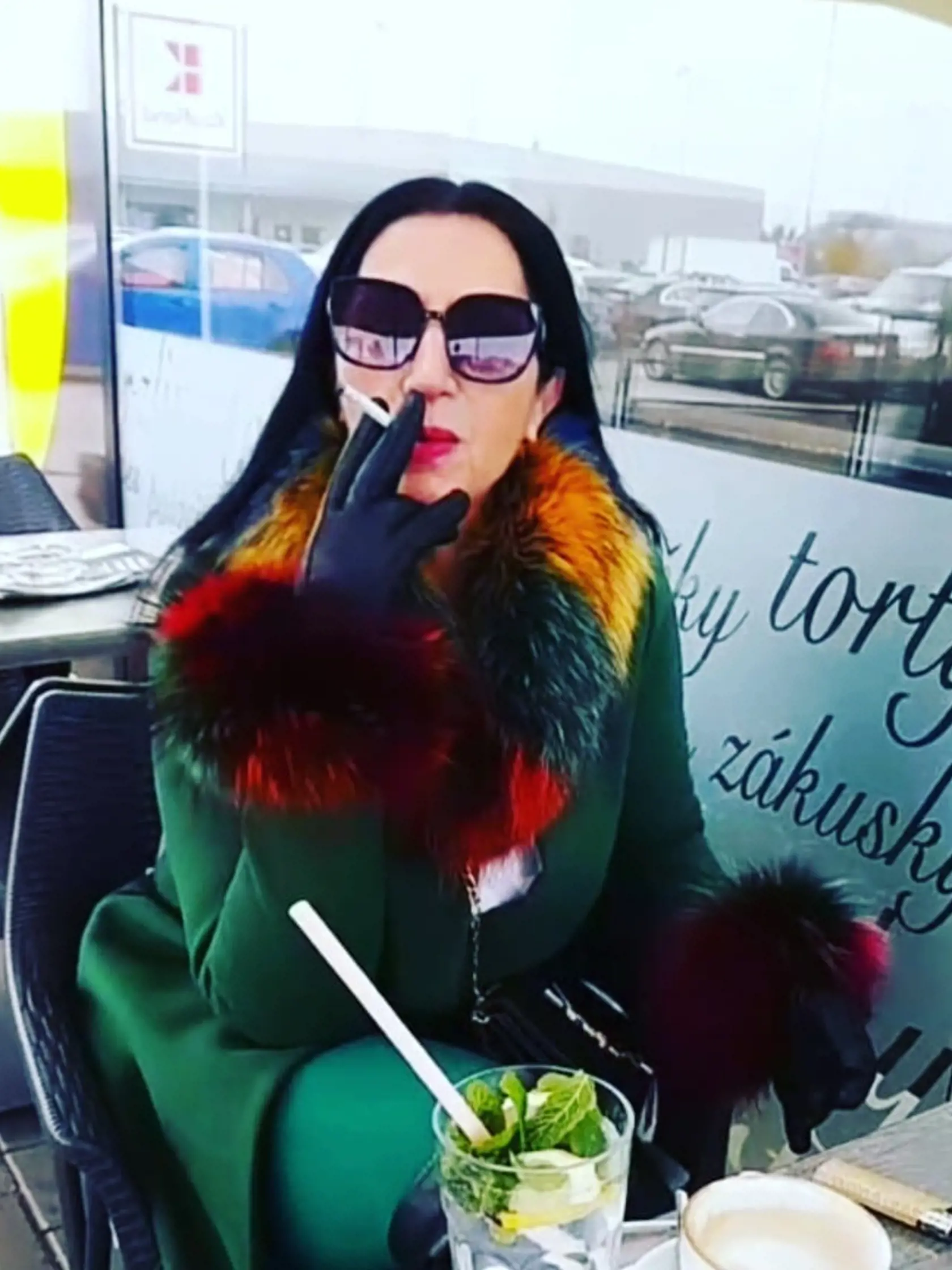 Norika vo svojom extravagantnom outfite a s cigaretkou v ruke.