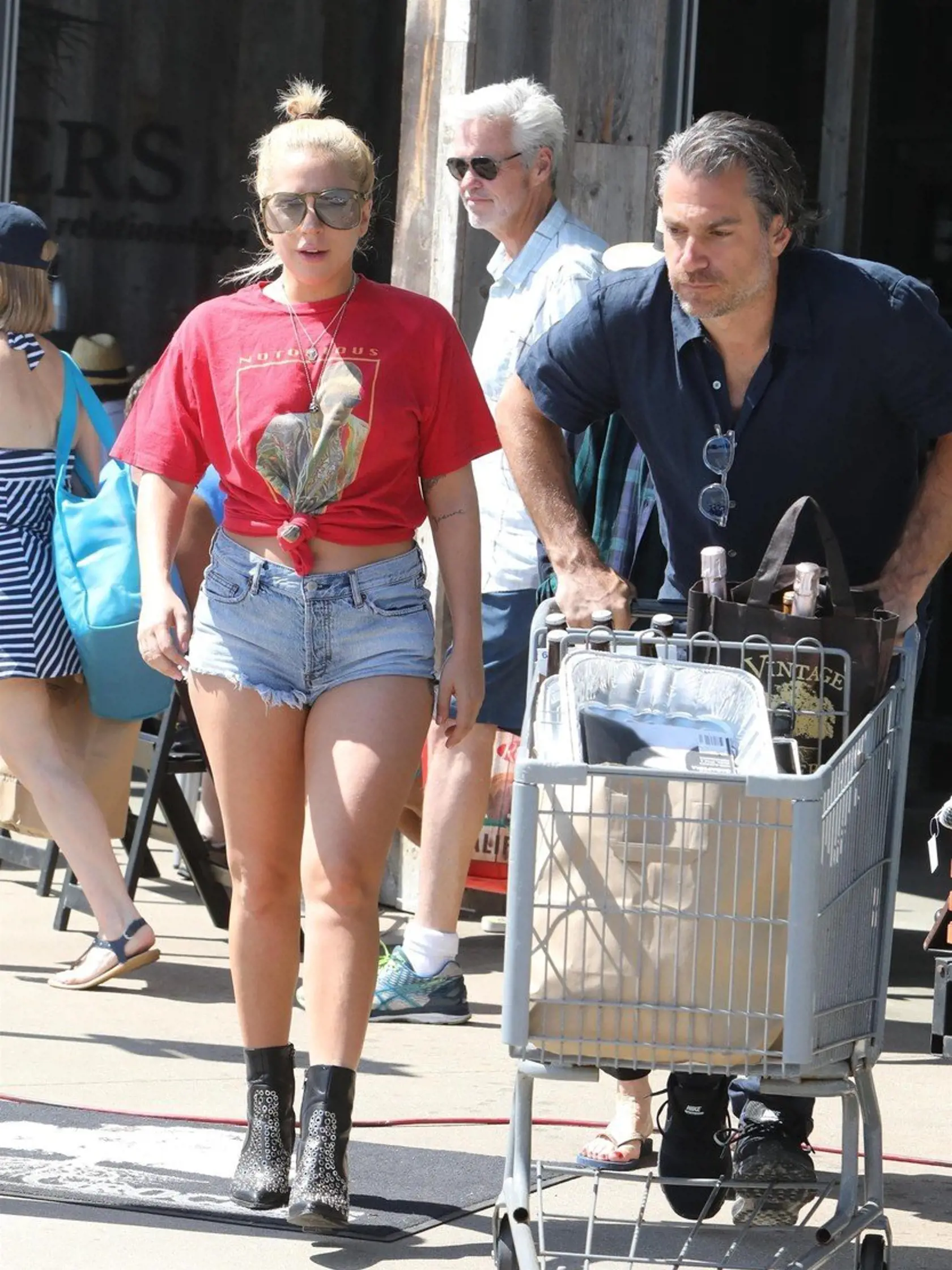 Malibu, CA  - Lady Gaga and her boyfriend, Christian Carino, go grocery shopping at Vintage Grocers ahead of the 4th of July holiday. The two are joined by Gaga's mom, Cynthia. The blonde singer is wearing denim shorts and a knotted red tee paired with ankle boots for a shopping trip.    Pictured: Lady Gaga    BACKGRID USA 2 JULY 2017     USA: +1 310 798 9111 / usasales@backgrid.com    UK: +44 208 344 2007 / uksales@backgrid.com    *UK Clients - Pictures Containing Children  Please Pixelate Face