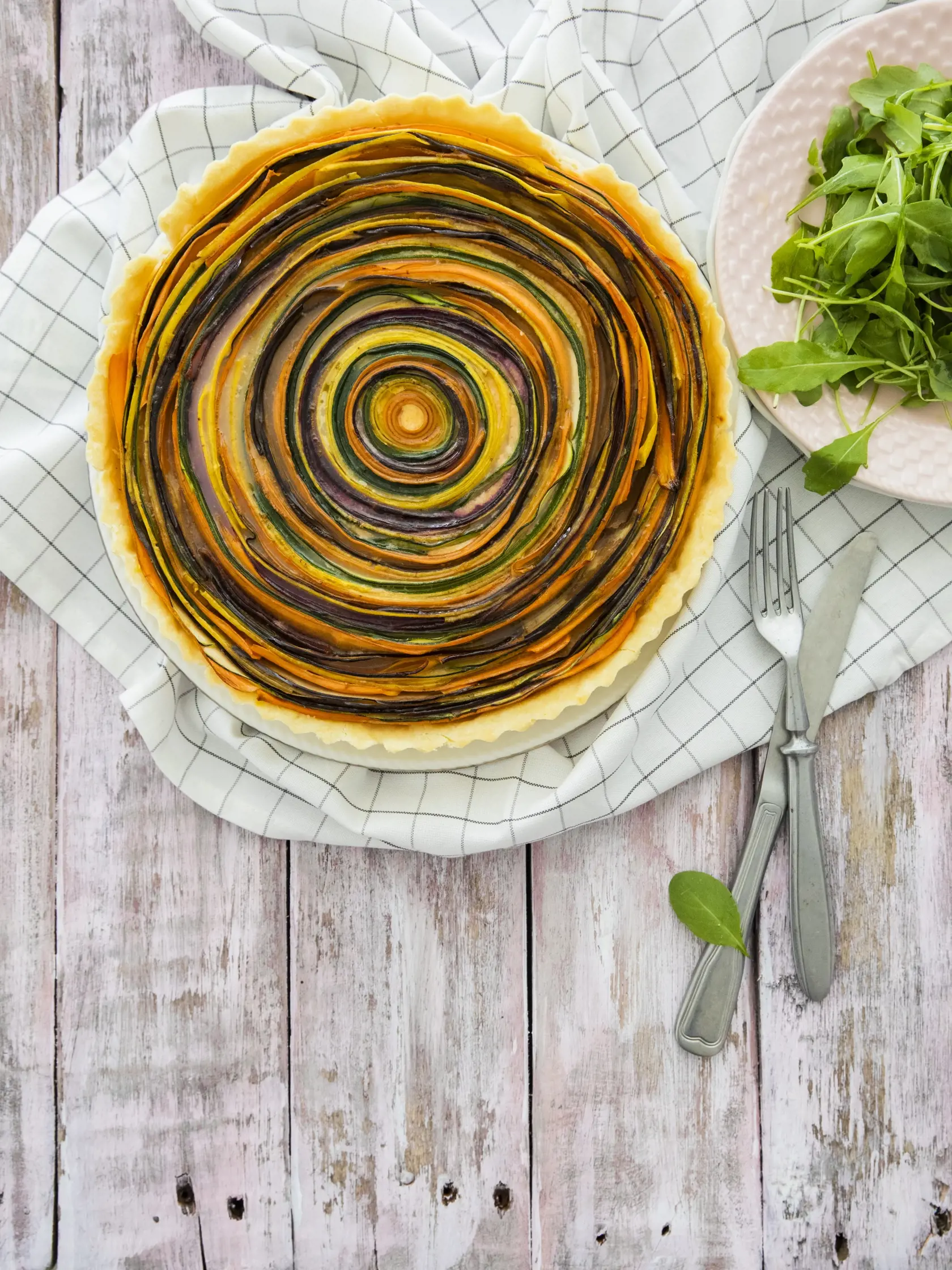 zeleninový tart

recept:
8 PORCIÍ, PRÍPRAVA 30 MINÚT + CHLADENIE
CESTA, PEČENIE 35 MINÚT
NA CESTO:
• 190g hladkej múky • 110g masla
(chladeného) • pol lyžičky soli • 1-2 lyžice
studenej vody
NA NÁPLŇ:
• 100g mozzarelly • 100g syra
gruyere • 100g parmezánu • 200g
kyslej smotany • soľ podľa chuti
• 1 vajce • mleté čierne korenie • štipka
muškátového orieška • pol lyžičky mletej
údenej papriky • 1-2 stredne veľké cukety
• 1 väčšia mrkva • 1 stredne veľká žltá
mrkva • 1 malý baklažán • 2-3 lyžice
ol