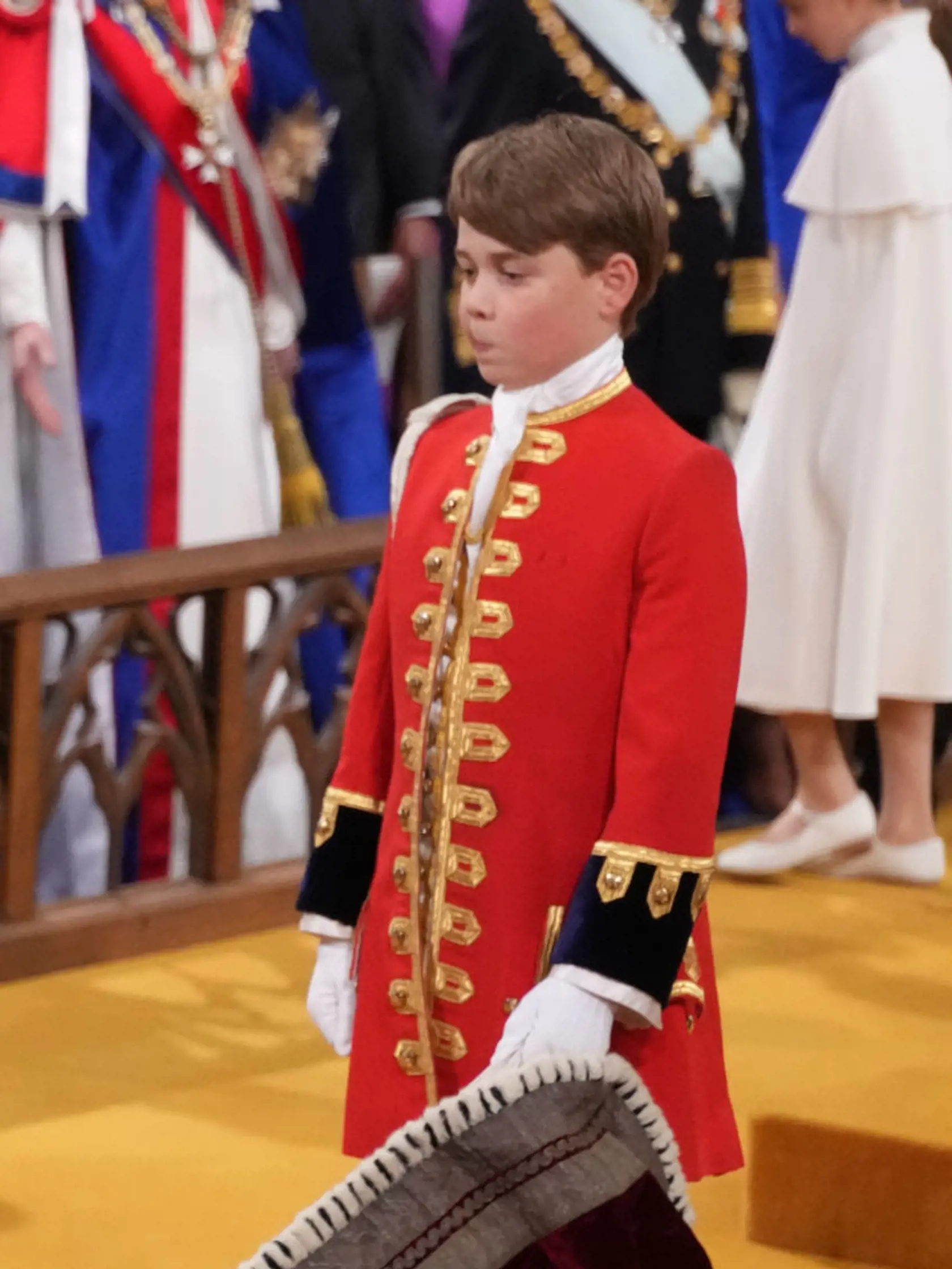 Princ George mal dôležitú úlohu - držal starému otcovi, kráľovi Karolovi III., rúcho. Ani on sa nevyhol grimasám
