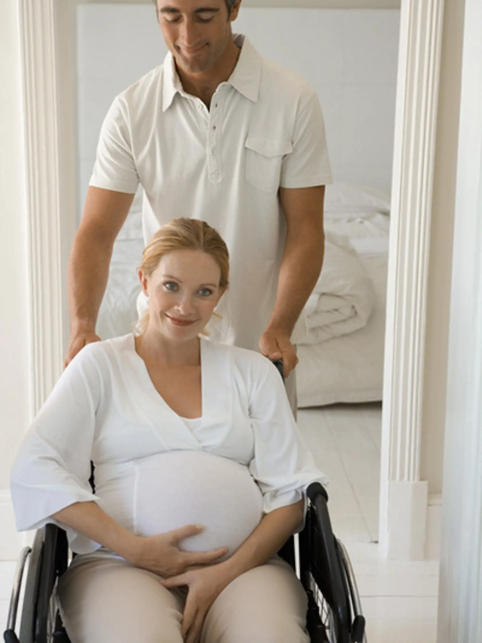 Man pushing woman in wheelchair