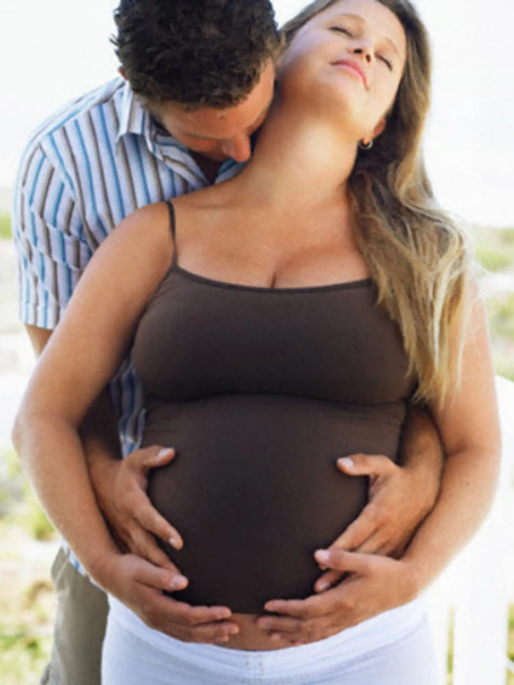 Man Embracing Pregnant Woman --- Image by © Brooke Fasani/Corbis