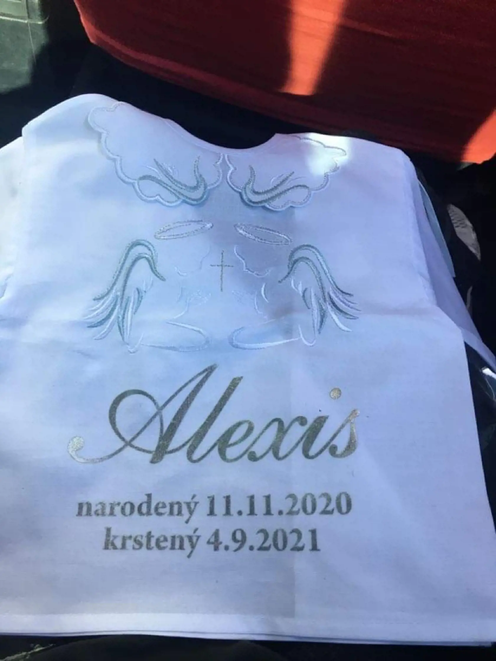 Alexisova krstná košieľka. O pár dní dovŕši usmievavý chlapček rok.