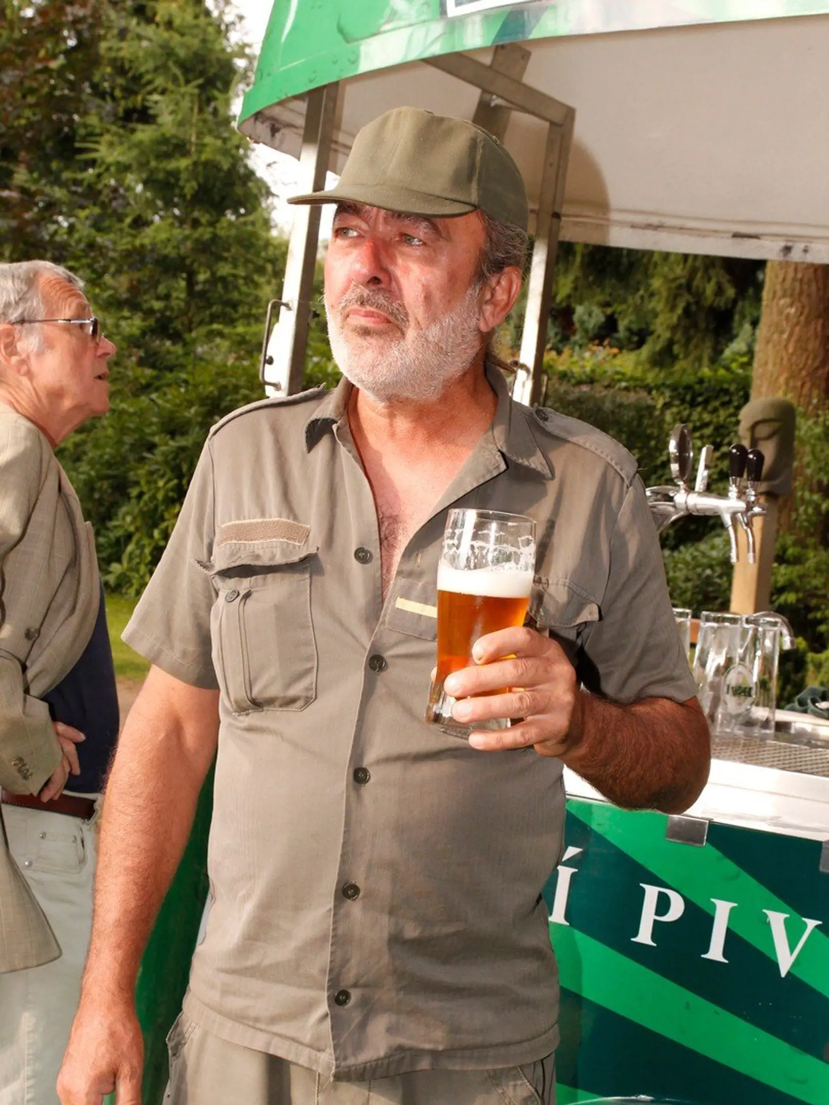 S pohárom piva v ruke a v uniforme vyzerá ako púštny vojak.

