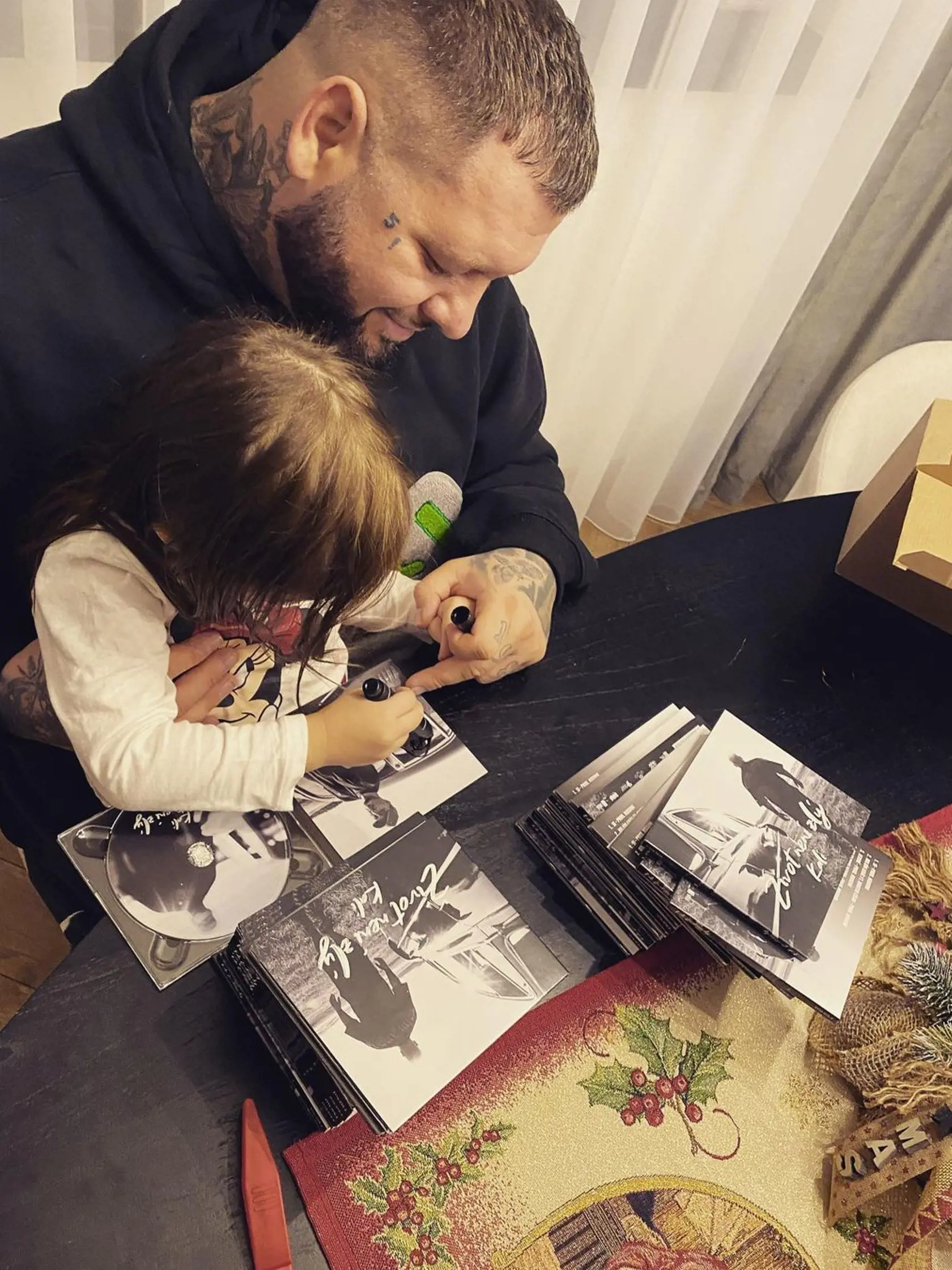 Kali s dcérkou podpisujú nový album pri jedálenskom stole.
