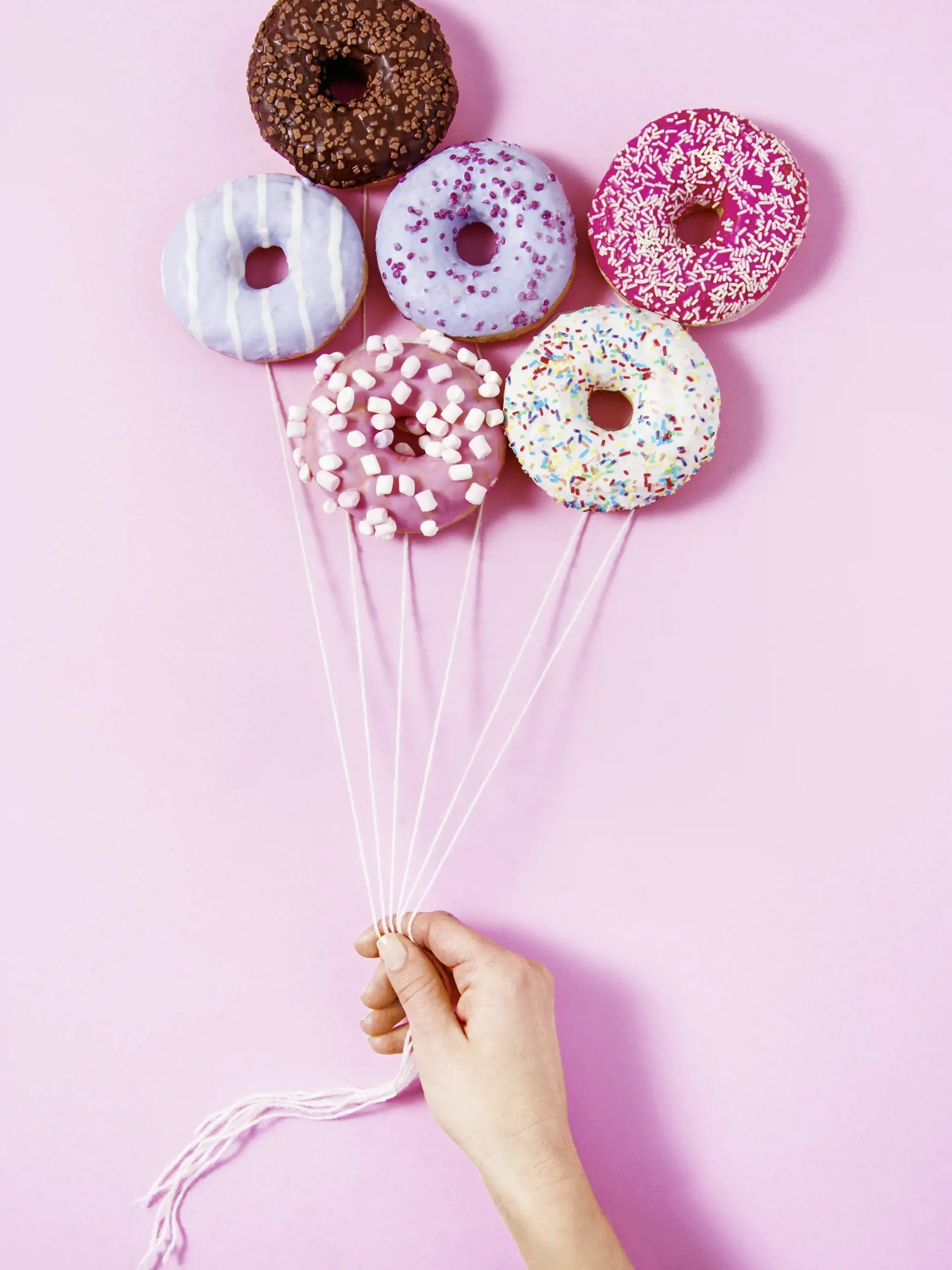 Donut,Ballons,Holding,By,A,Woman's,Hand.,Sweetness,Happiness,Abstract