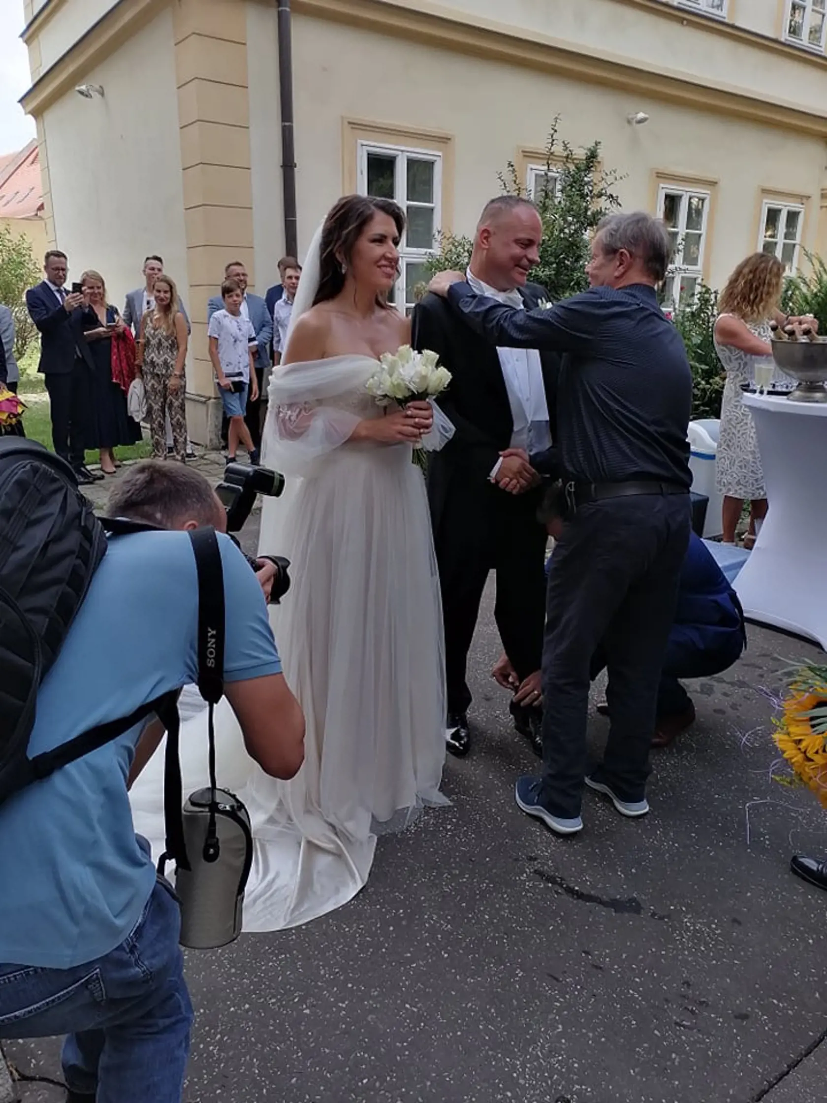 Svadobní hostia gratulujú mladomanželom.