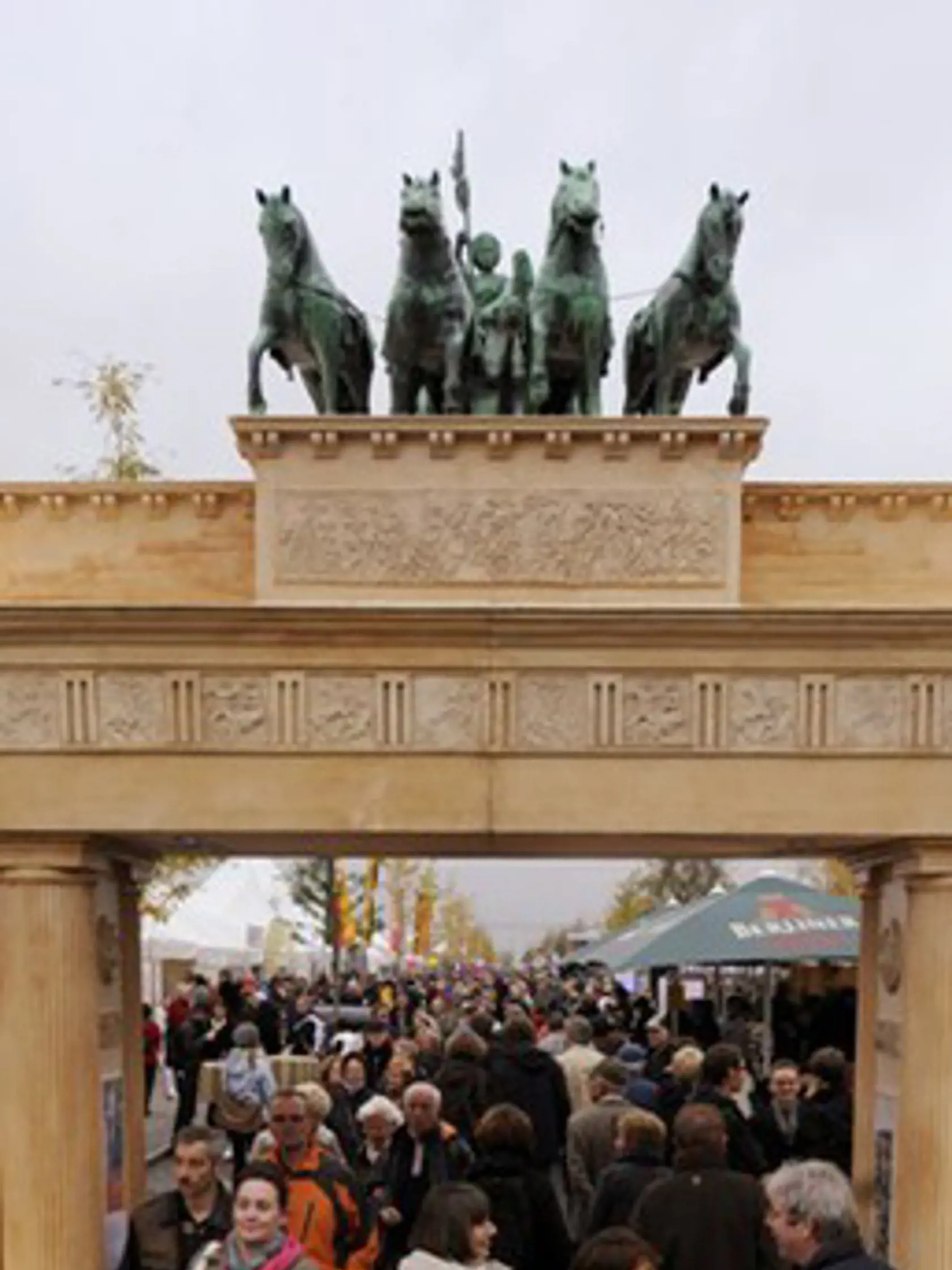 Účastníci prechádzajú maketou Brandenburskej brány.