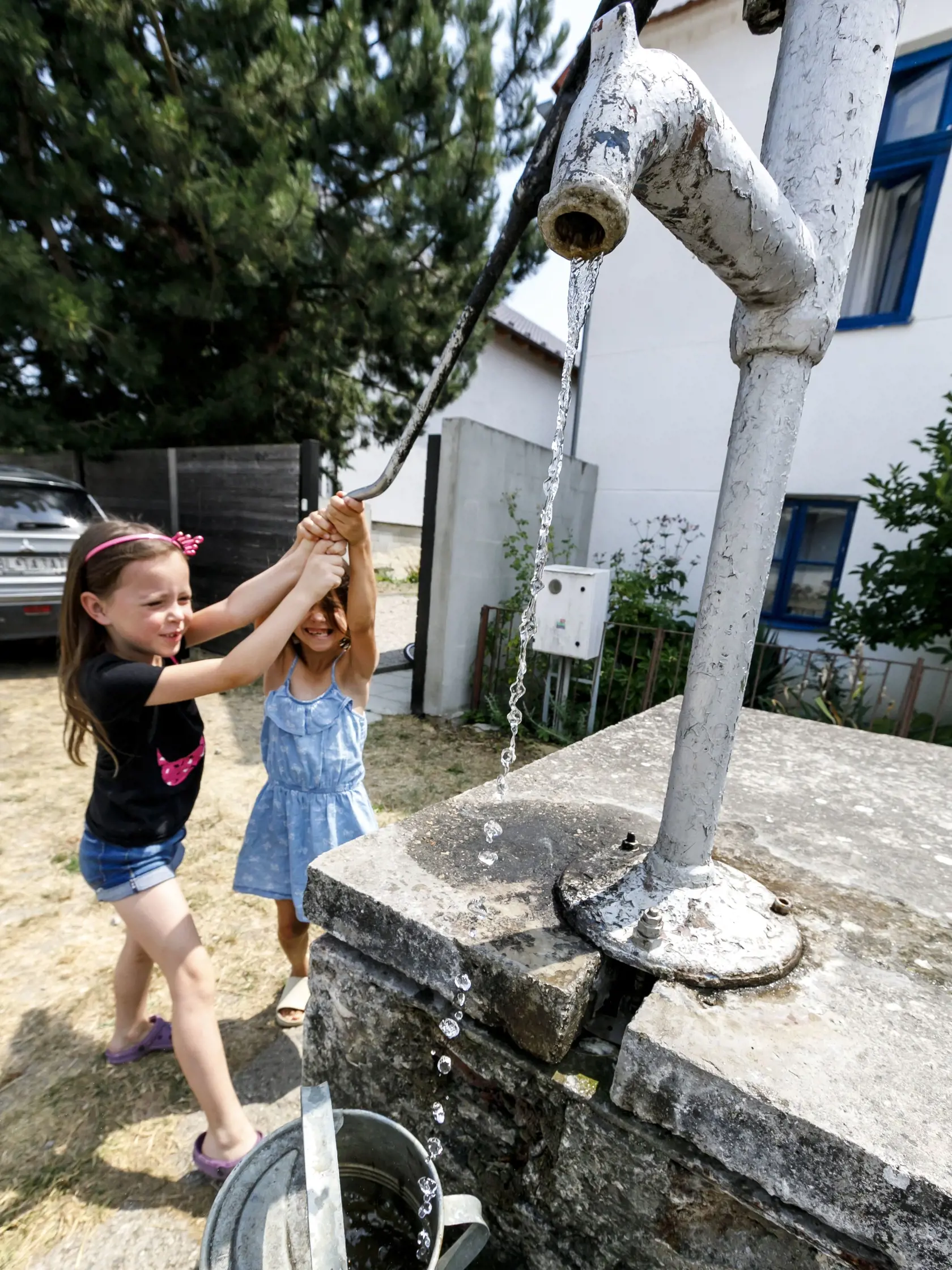 Extrémne sucho, ako aj vysoká spotreba vody počas mimoriadne teplých dní spôsobili, že viacerým obciam na Záhorí hrozí nedostatok vody vo verejných vodovodoch. Nedostatok vody sa týka viacerých obcí v záhorskom aj senickom skupinovom vodovode. Ide predovšetkým o obce Prievaly, Osuské, Jablonica, Cérová, Borský Mikuláš, Rohožník, Studienka a Lakšárska Nová Ves. Na snímke deti čerpajú vodu z obecnej studne v obci Osuské, okres Senica v utorok 26. júla 2022. FOTO TASR - Dano Veselský