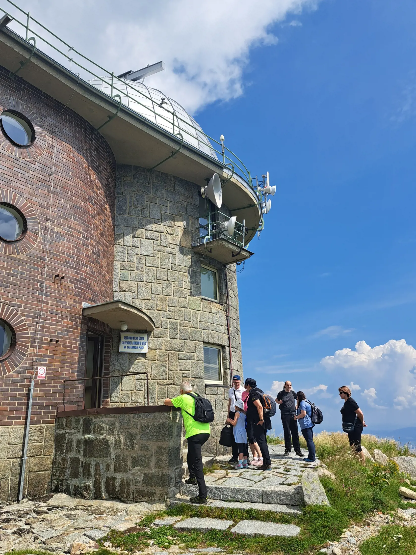 Návštevníci Skalnatého plesa vo Vysokých Tatrách mohli v sobotu 19. augusta 2023 nahliadnuť do pracoviska Astronomického ústavu Slovenskej akadémie vied. Pri príležitosti 80. výročia vzniku tatranského observatória tam totiž zorganizovali deň otvorených dverí.  Na snímke turisti pred  observatóriom na Skalnatom plese. FOTO TASR - Adriána Hudecová 